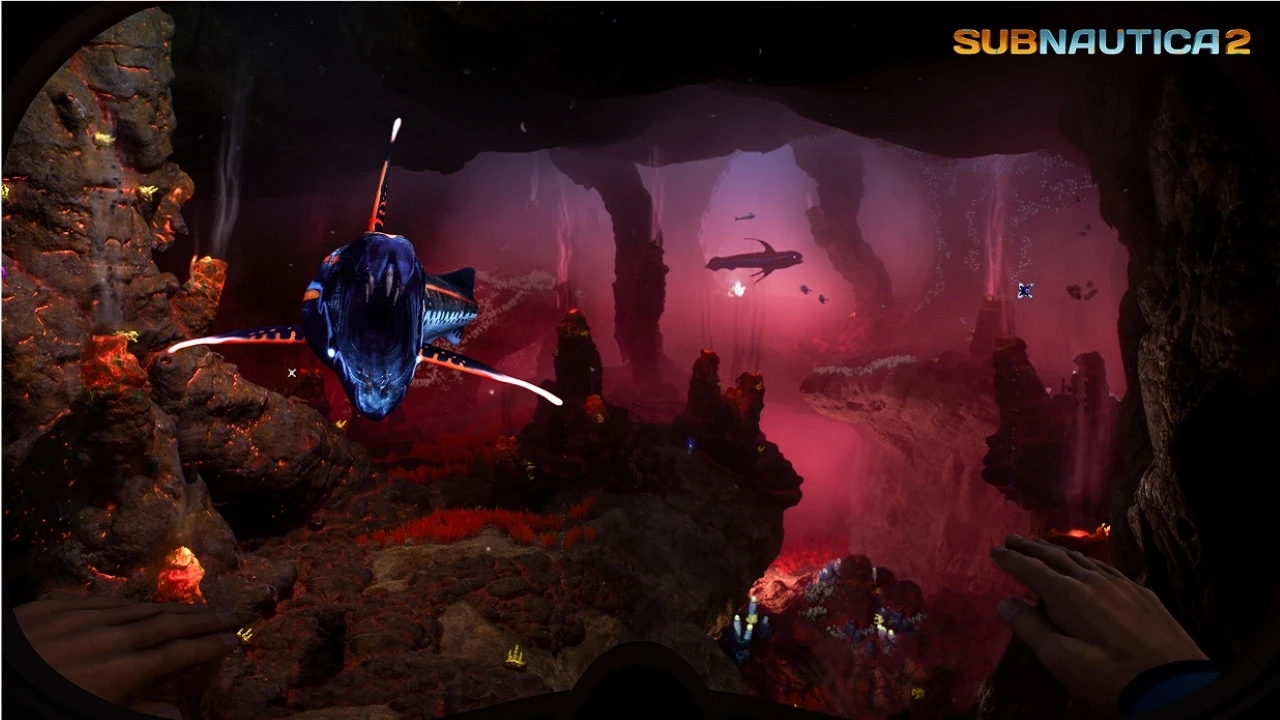A diver explores a vibrant underwater cave in "Subnautica 2," surrounded by glowing sea creatures and illuminated by red and purple hues.