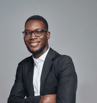 a man in a suit and glasses posing for a picture