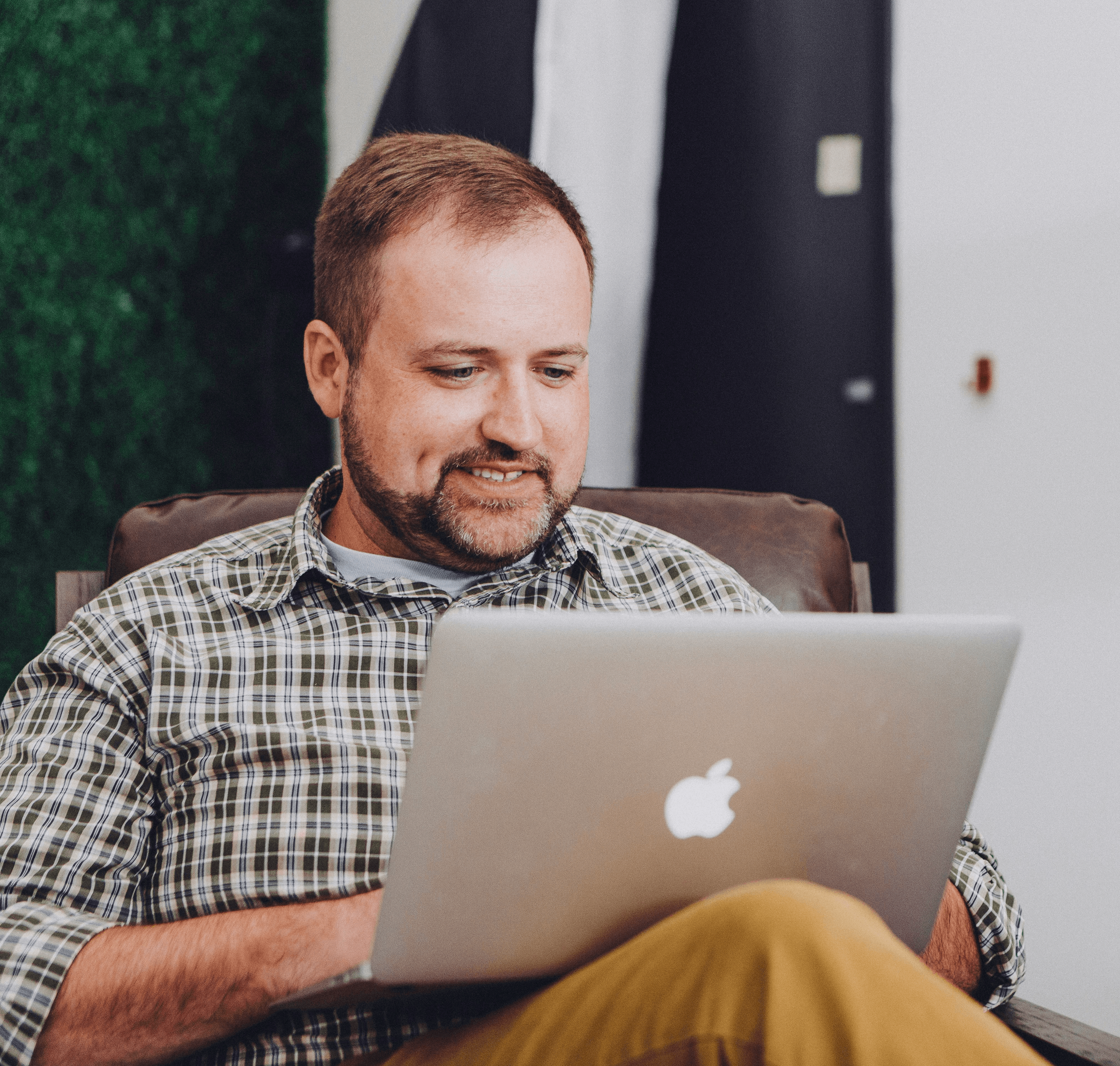 man smiling and using MacBook