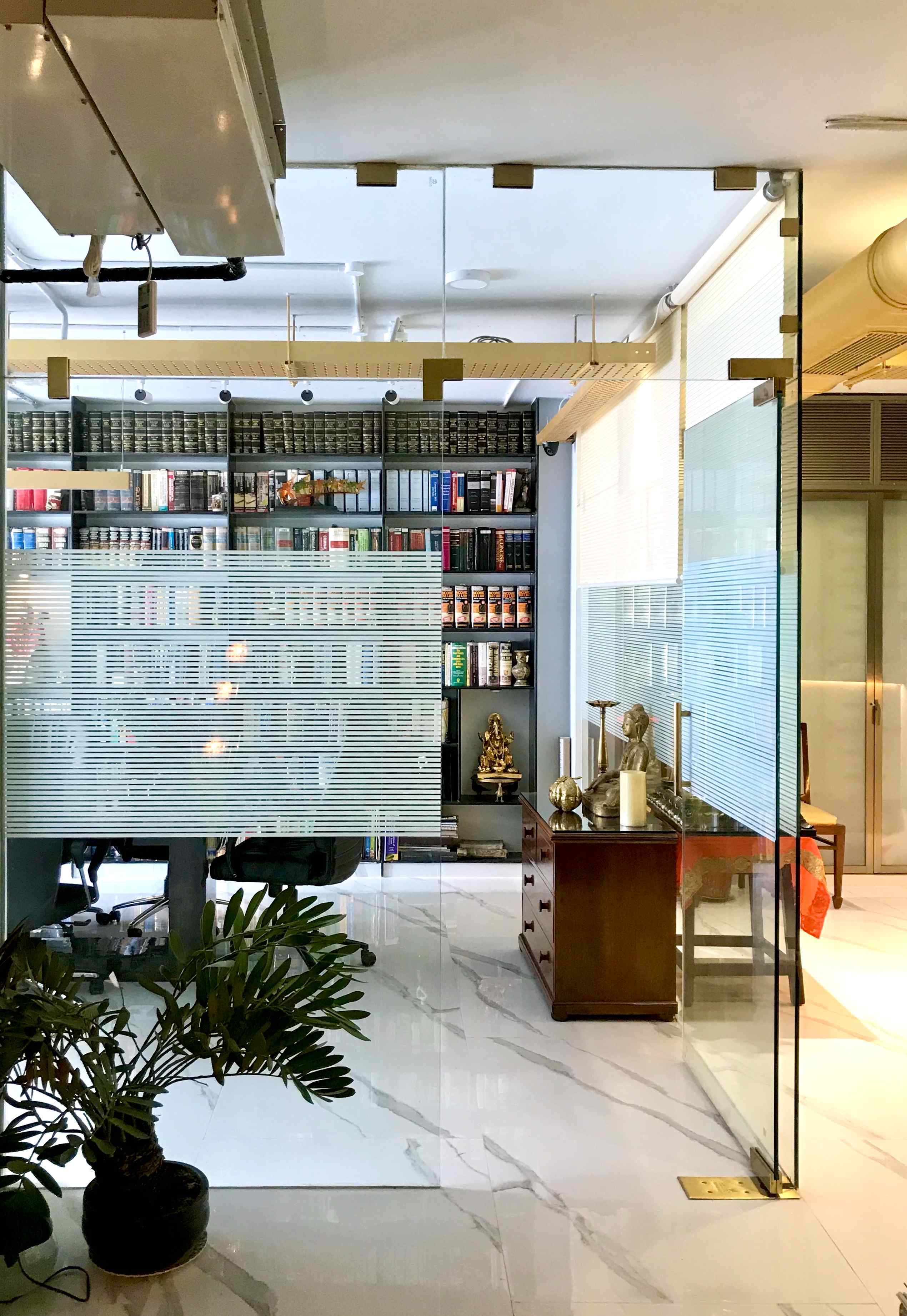 Nature-inspired preschool entrance with sculptural tree partitions and suspended green leaf ceiling panels.