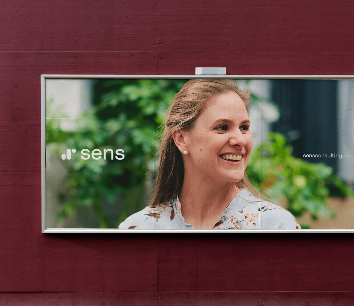 A billboard poster designed for Sens Consulting showing their logo and a business woman smiling.