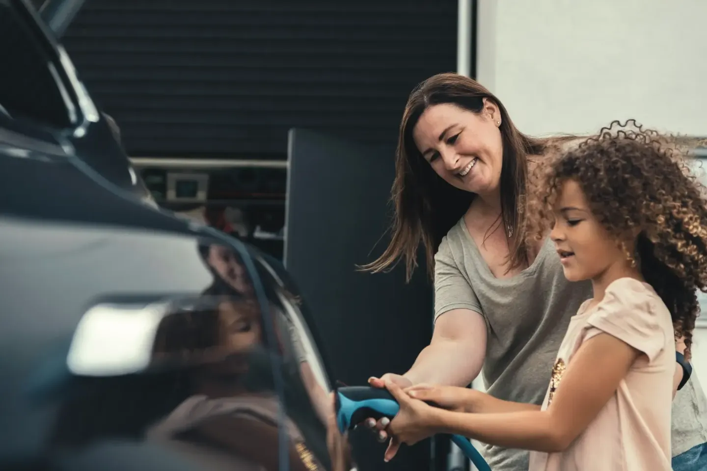 Madre e hija cargando un coche eléctrico en Murcia con la seguridad del seguro Allianz para EV