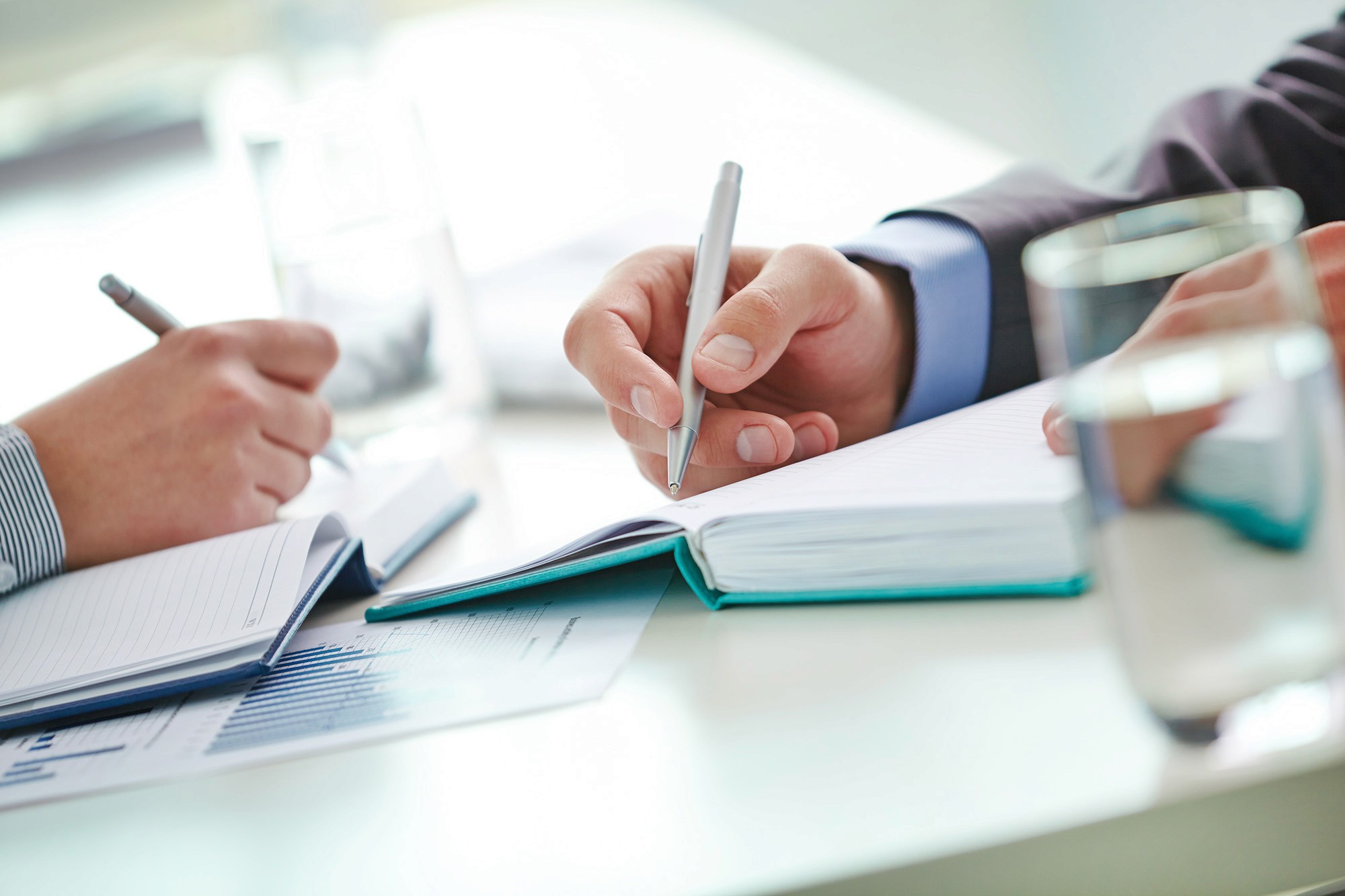 Close-up of hands writing notes during a meeting