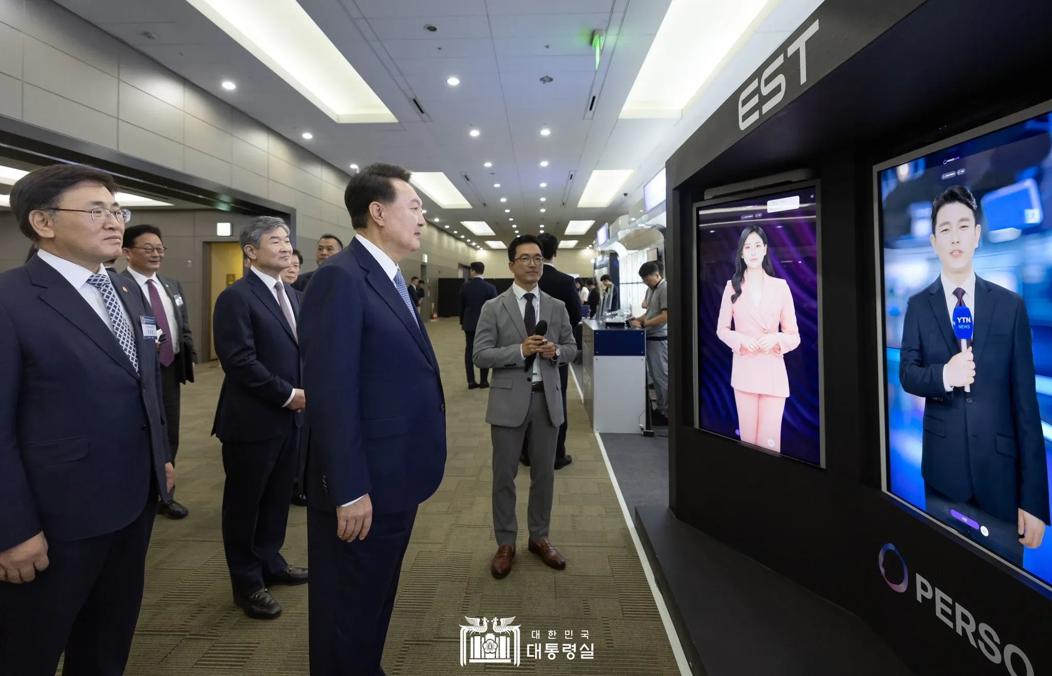 ประธานาธิบดีเกาหลีใต้ ยุน ซอกยอล กำลังสังเกตการใช้งานของ AI Human Kiosks แบบโต้ตอบของ ESTsoft ที่ขับเคลื่อนโดย Perso ในงาน Cyber Summit Korea