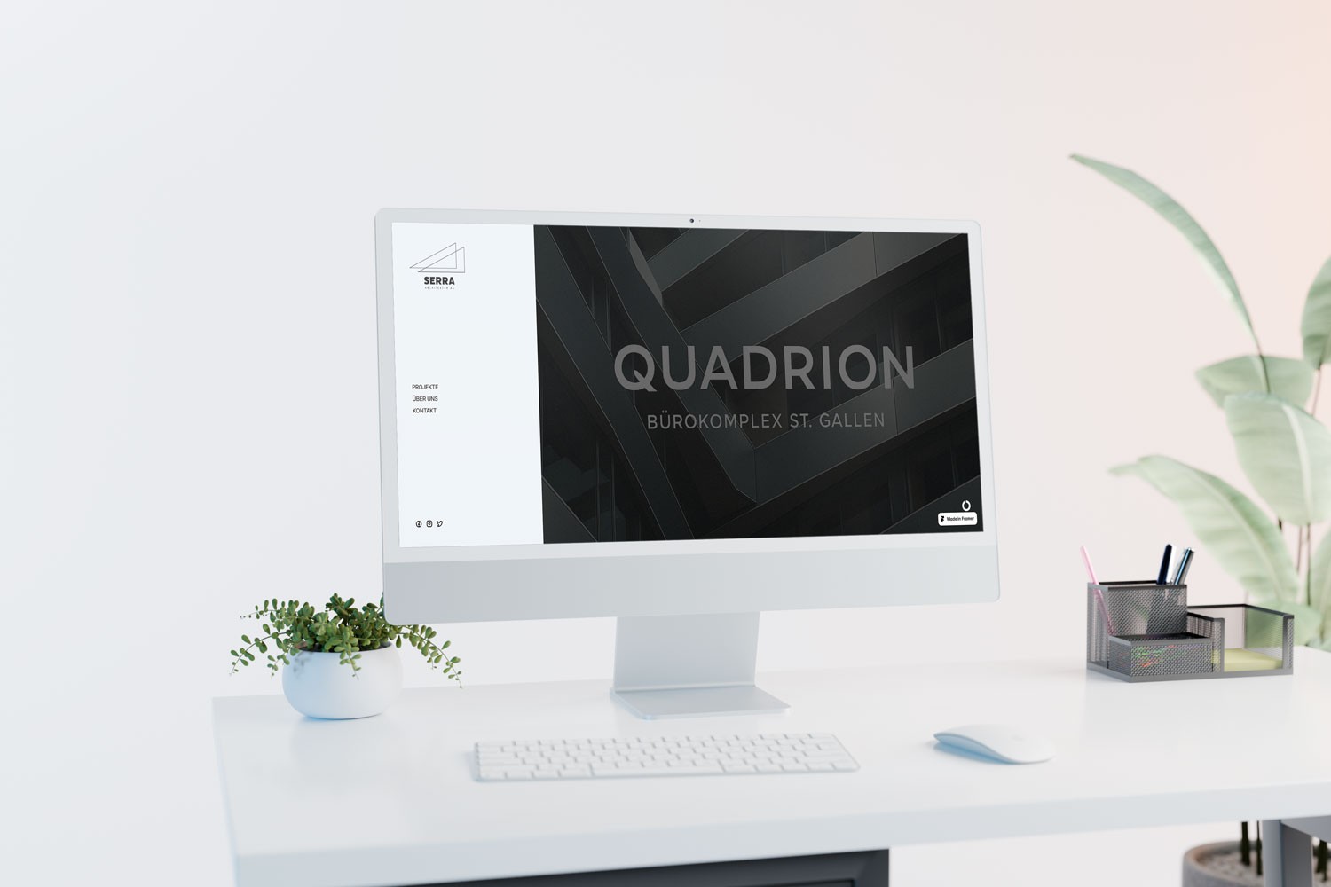 iMac auf einem weißen Schreibtisch zeigt die moderne Website des Architekturunternehmens Serra mit dem Projekt ‚Quadrion – Bürokomplex St. Gallen‘. Neben dem Bildschirm stehen eine kleine Pflanze, Stiftehalter und Computerzubehör