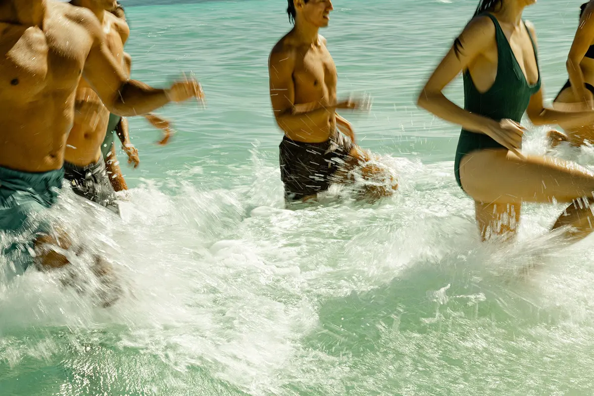 Personas haciendo un entrenamiento de intervalos de alta intensidad (HIIT) en la playa en Nomade Holbox México, con ejercicios como lunges y squats