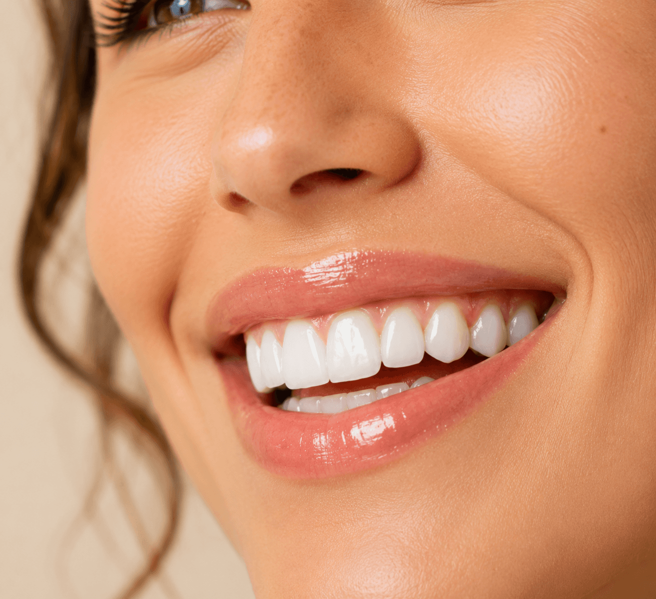 Close-up of glossy lips and white teeth.