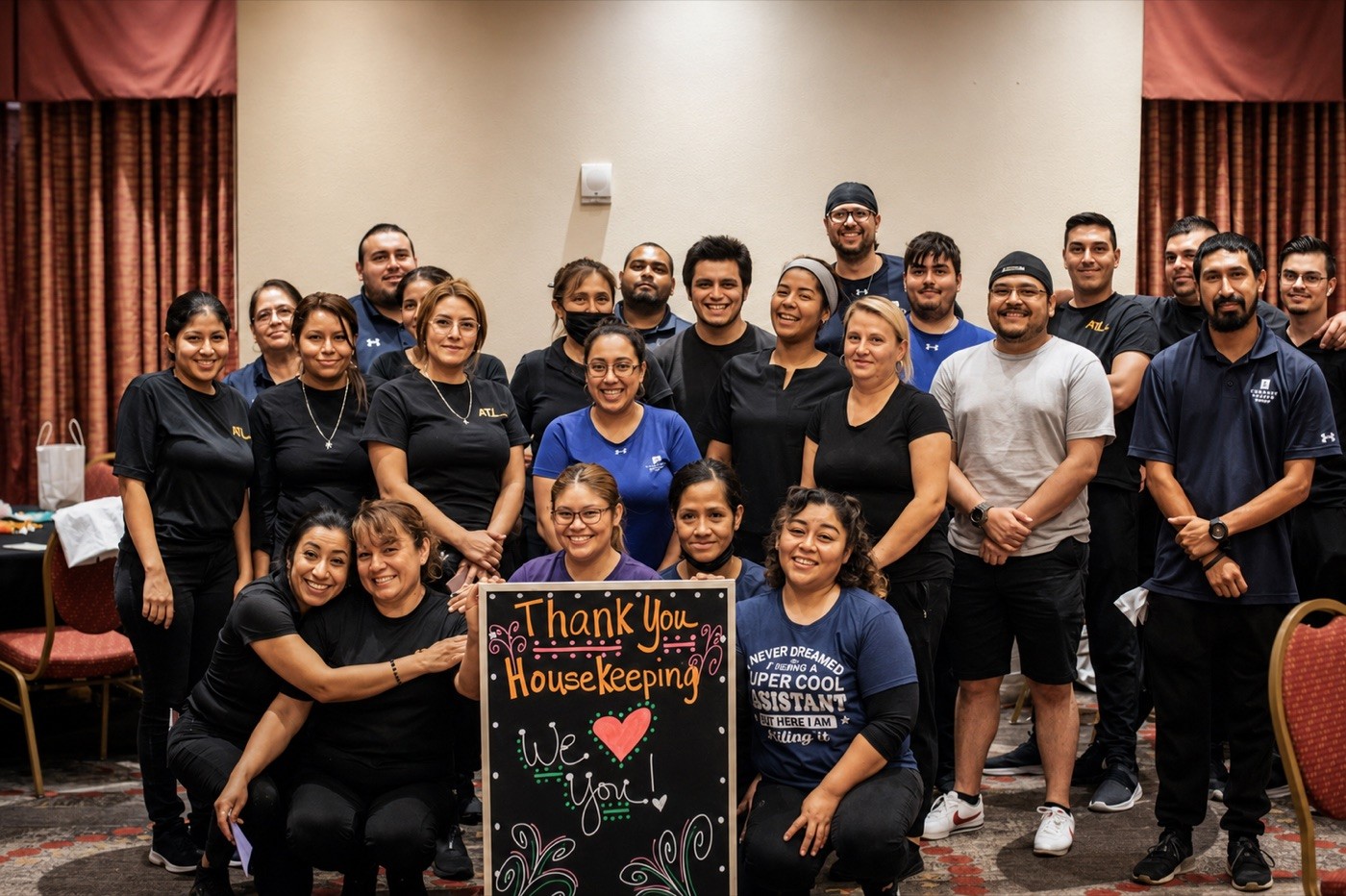 ATI team at a banquet holding a Thank You Housekeeping banner