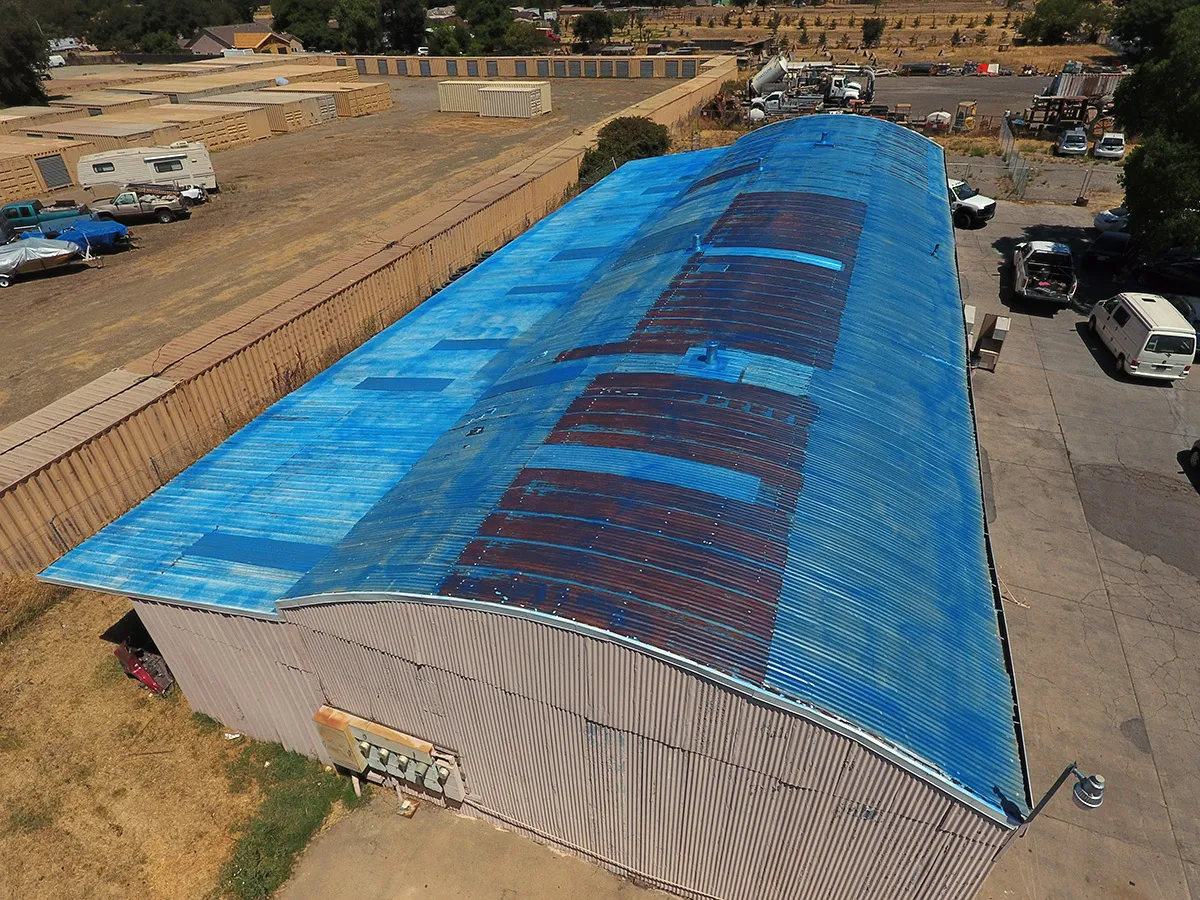 Commercial corrugated metal roof cleaned and primed for spray foam roofing system
