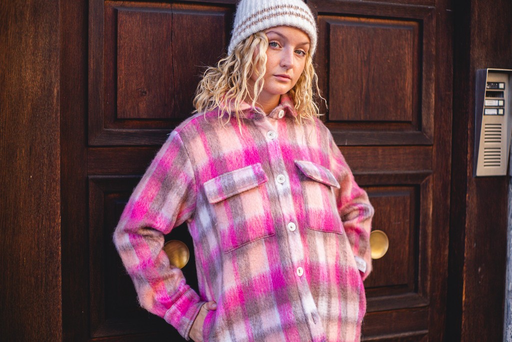 A young woman in stylish casual wear, representing a modern youth **customer profile**.