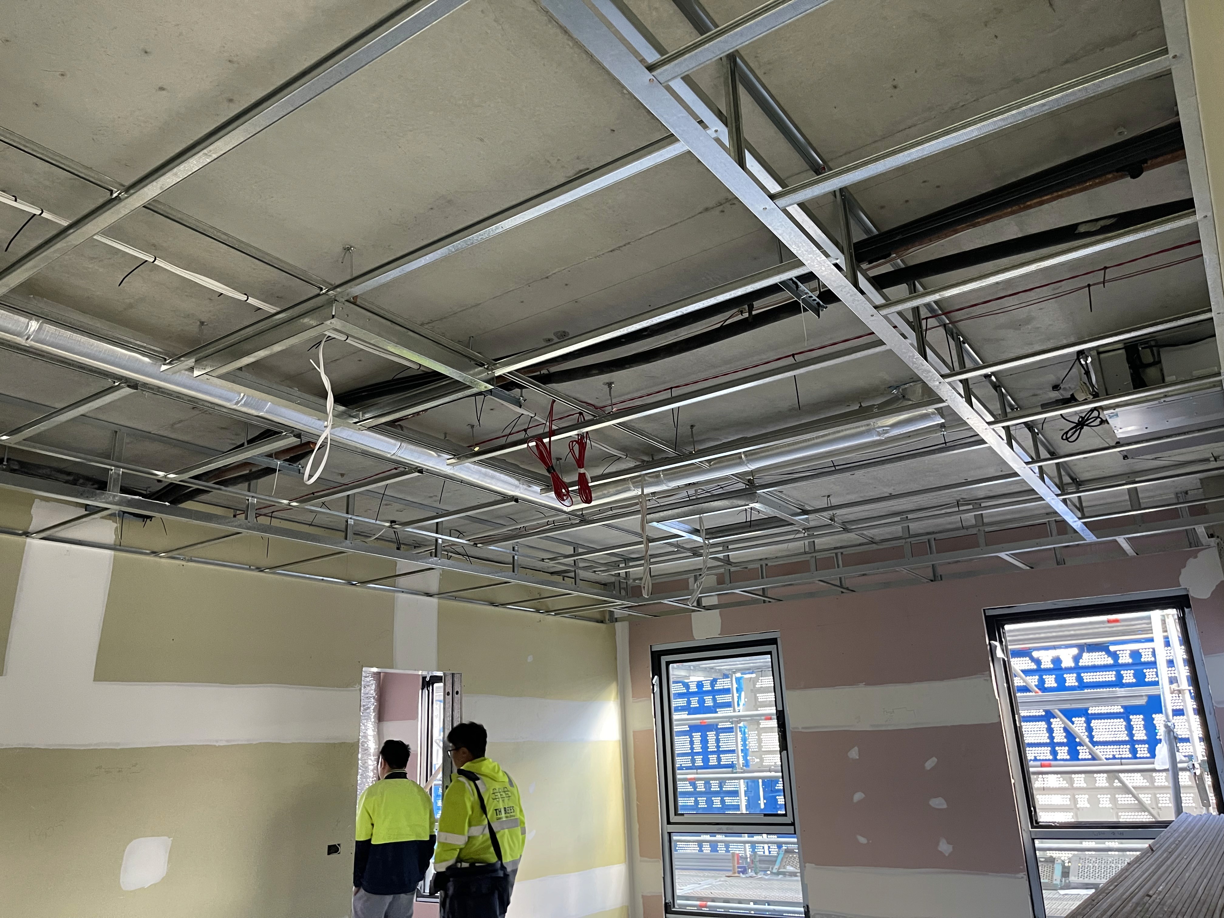Modern bathroom featuring a walk-in shower, wooden vanity, round mirror, and elegant marble tiles.