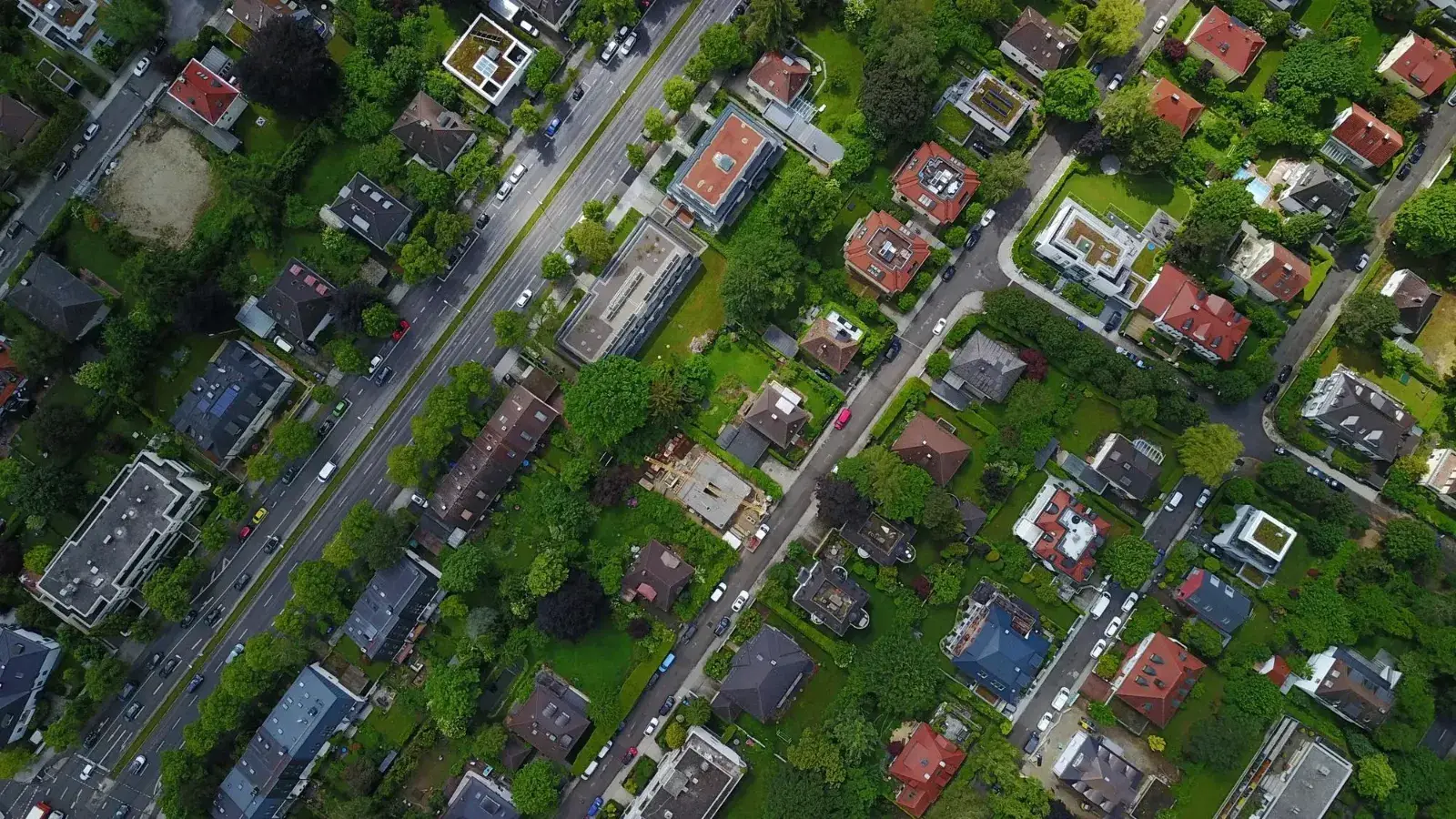 Aerial view of a residential neighborhood with tree-lined streets and houses, symbolizing property investment and real estate growth. The image represents the variety of housing opportunities available through Investment Loans from Chris Lewis Home Loans.