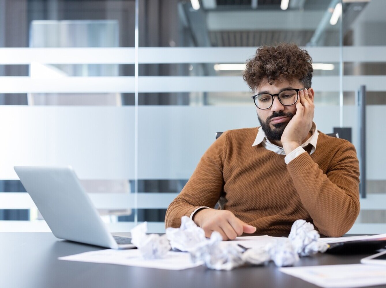 man feeling fatigued at work after overdoing it with cycling and weight loss