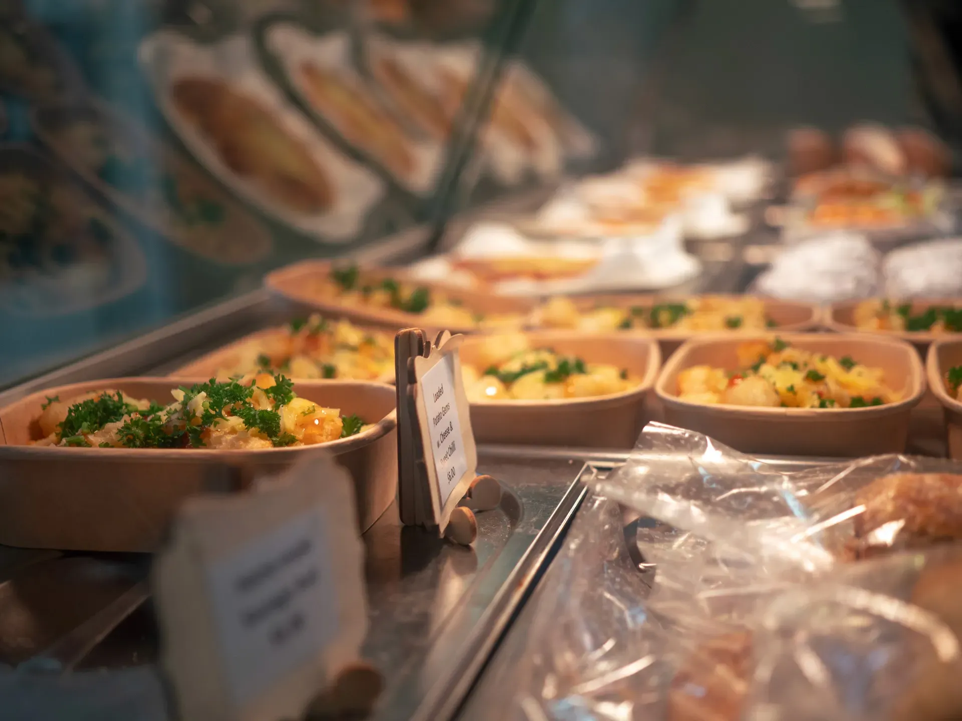 Containers of freshly cooked meals in a glass window