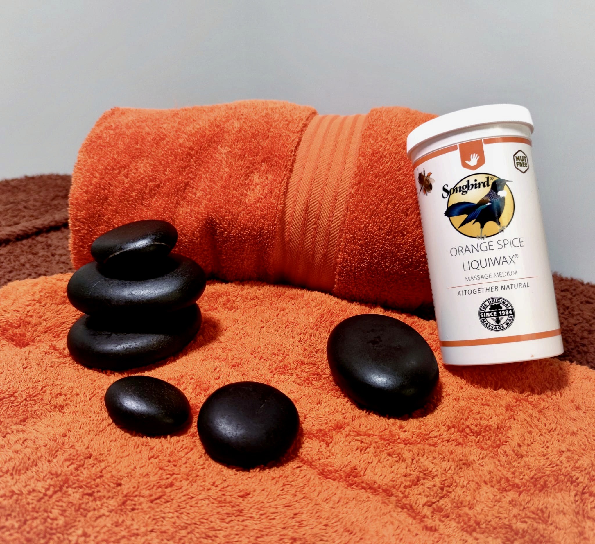 Hot Stone Massage Image Shows Stones on an Orange Towel