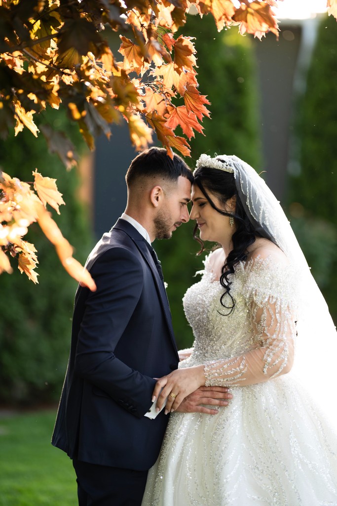 A bride in a lace wedding dress gently holds.