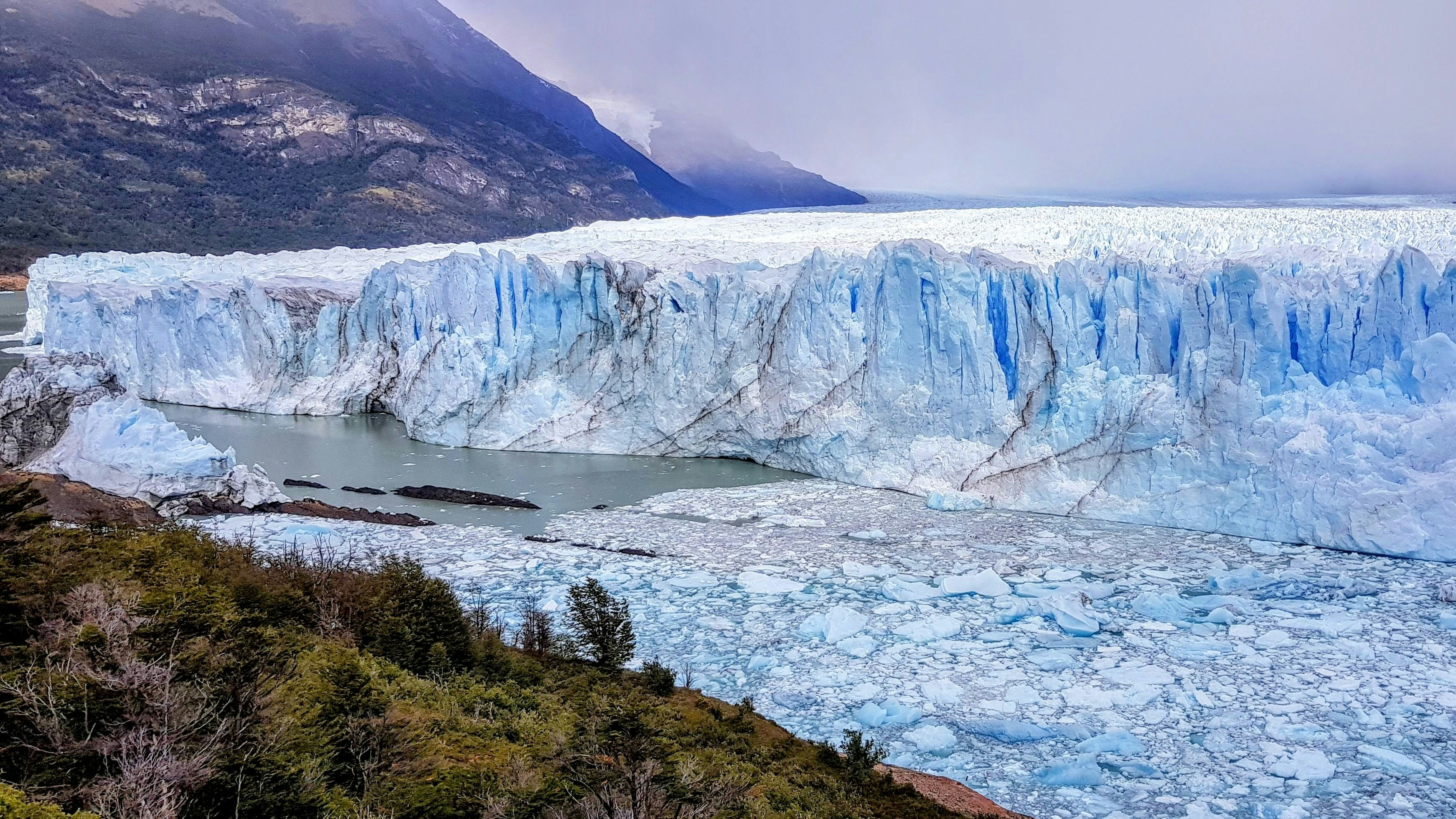 A large glacier with a mountain in the background