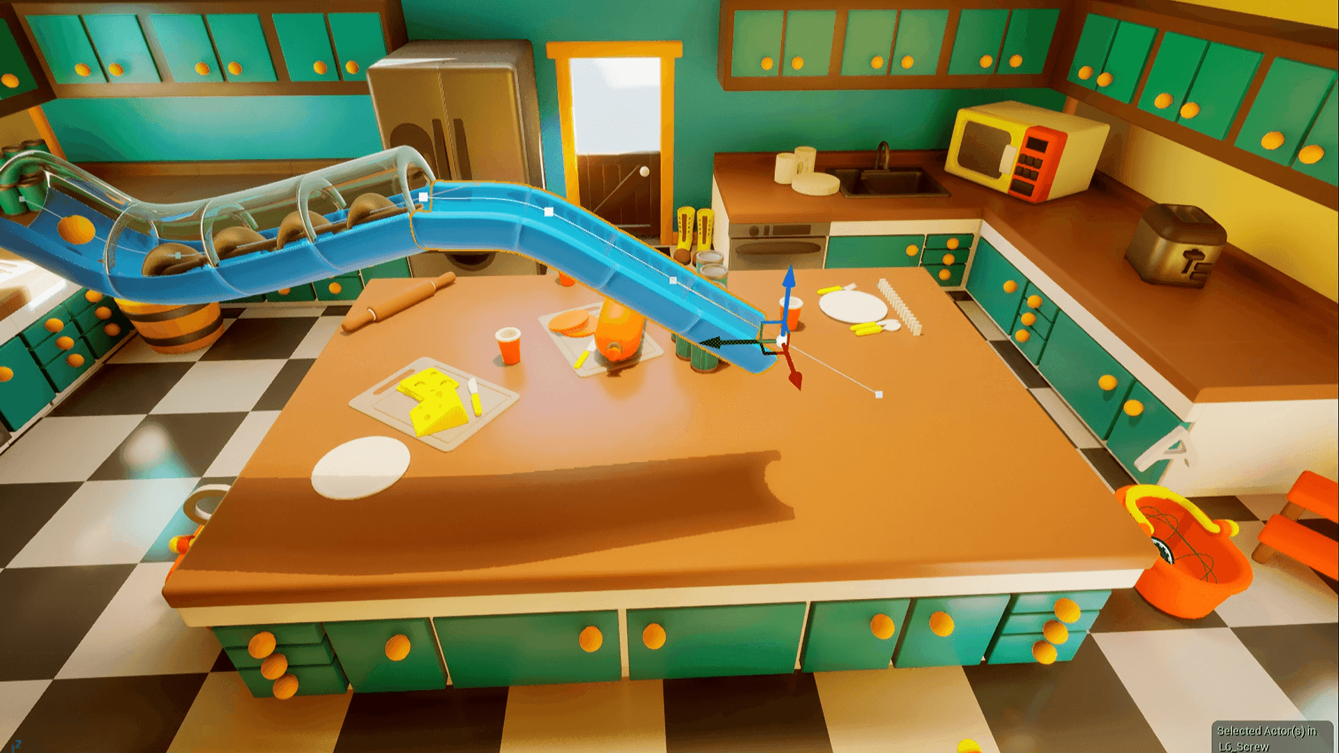 A colorful, stylized 3D kitchen scene viewed from above and slightly angled. The kitchen features teal cabinets with yellow knobs, a large central island, a refrigerator, microwave, sink, and other appliances. On the countertop are plates, utensils, cheese, and food items. A bright blue curved slide-like structure runs across the island, with visible 3D transformation controls and guide handles, suggesting the scene is being edited in a game engine or 3D design software. The overall aesthetic is playful and cartoon-like.