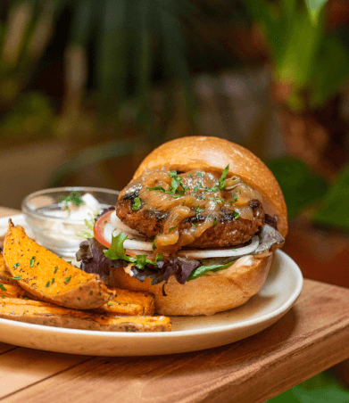 Vegan burger with caramelised onion and sweet potato wedges at Faire. Brunch & Drinks