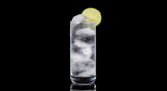 A closeup of a Vodka Soda drink against a dark background.