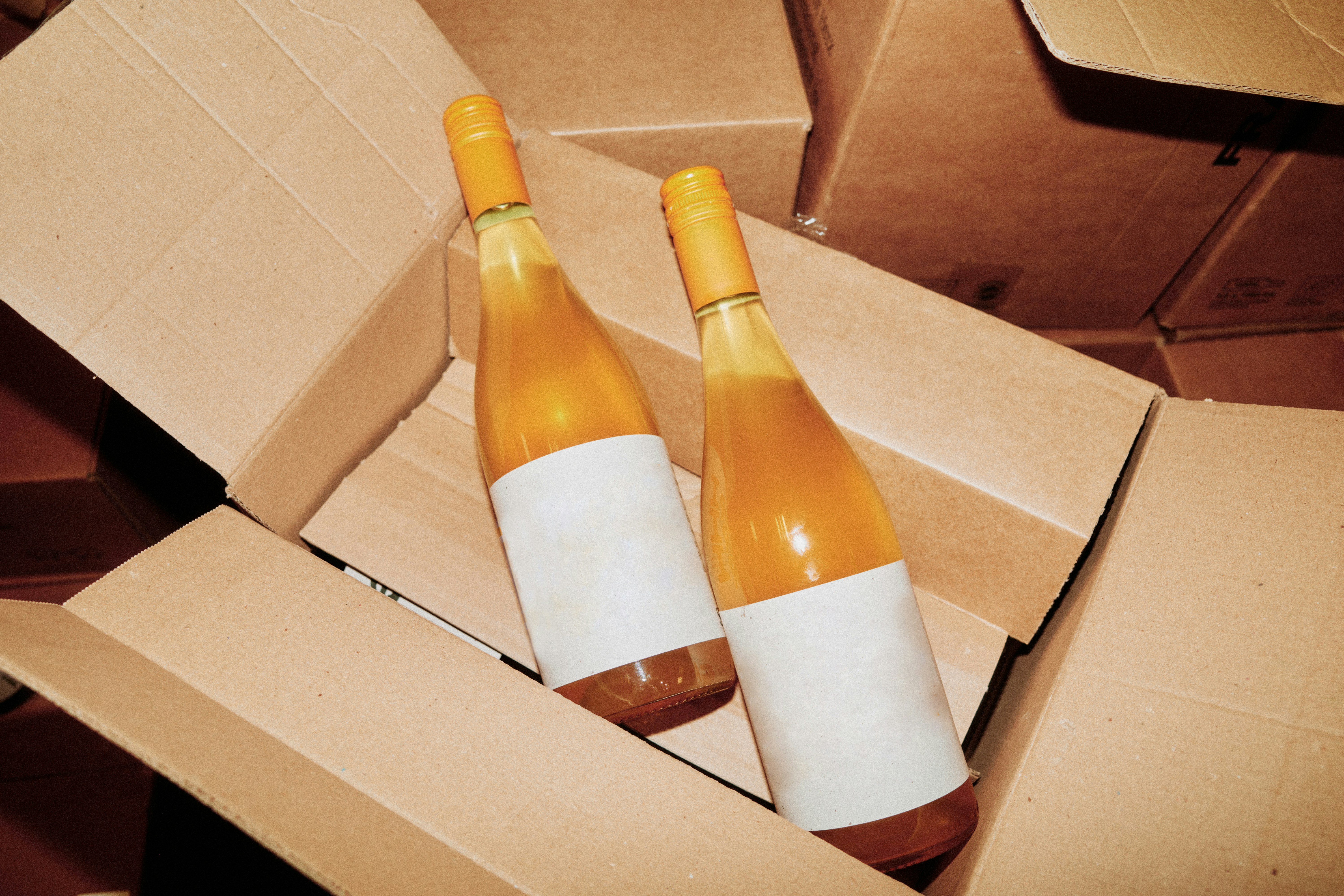 light coloured wine in bottles in a cardboard box