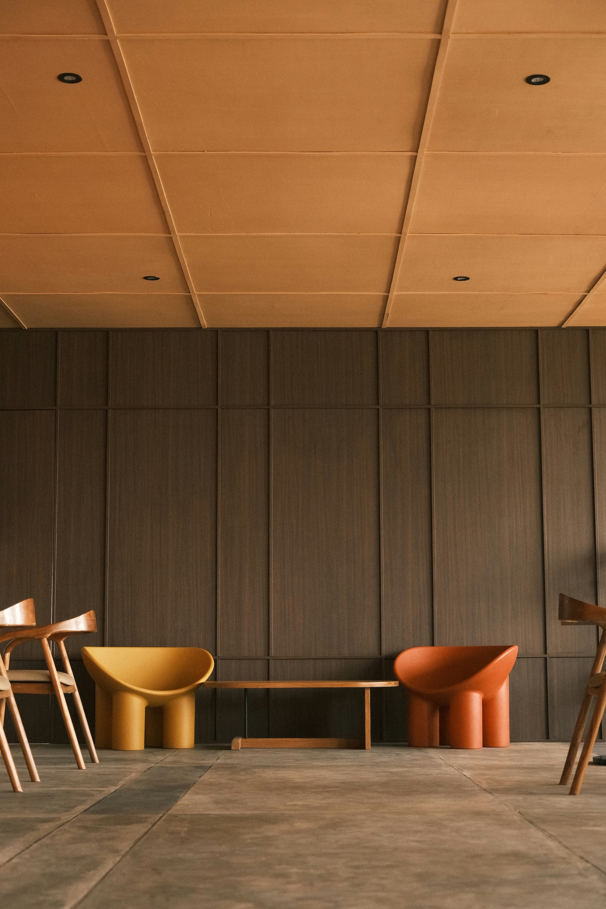 Modern chairs and bench in a room.