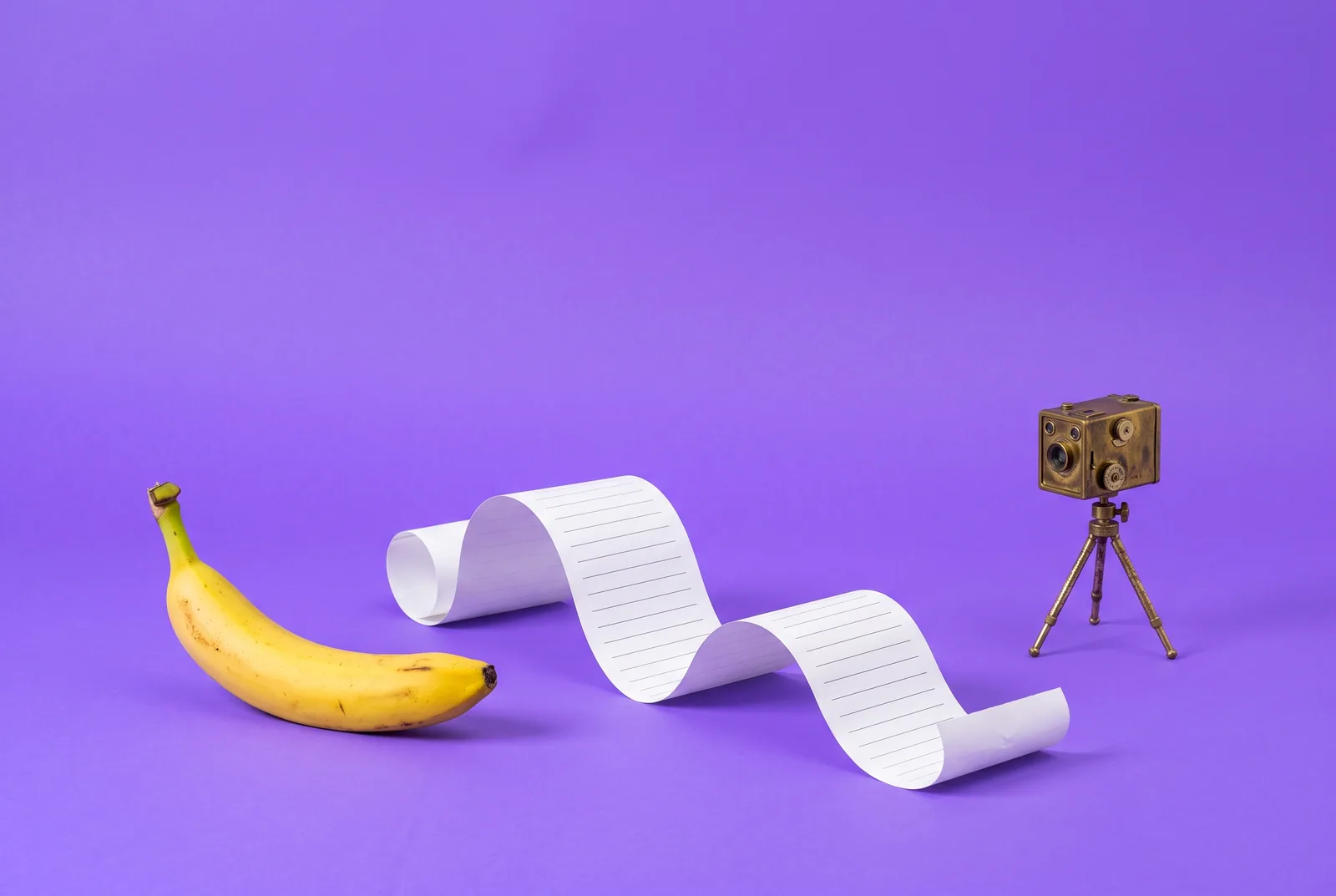A banana between a blank paper log strip and a vintage box camera, how Accountable2You vs Covenant Eyes each work