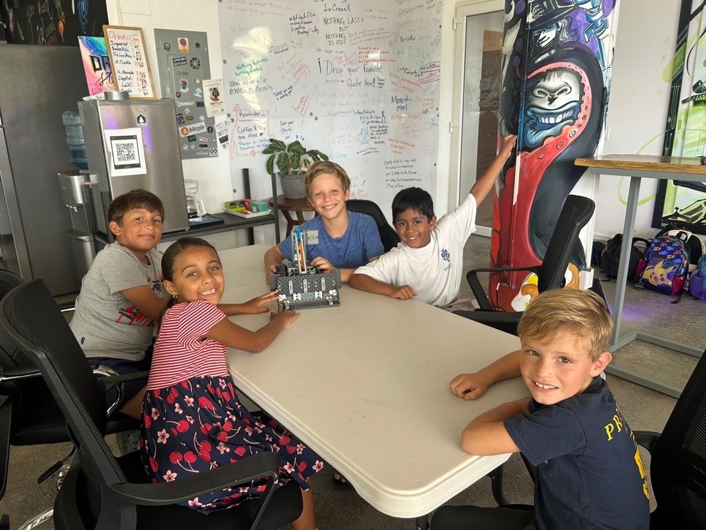 Children gathered around a table with a project.