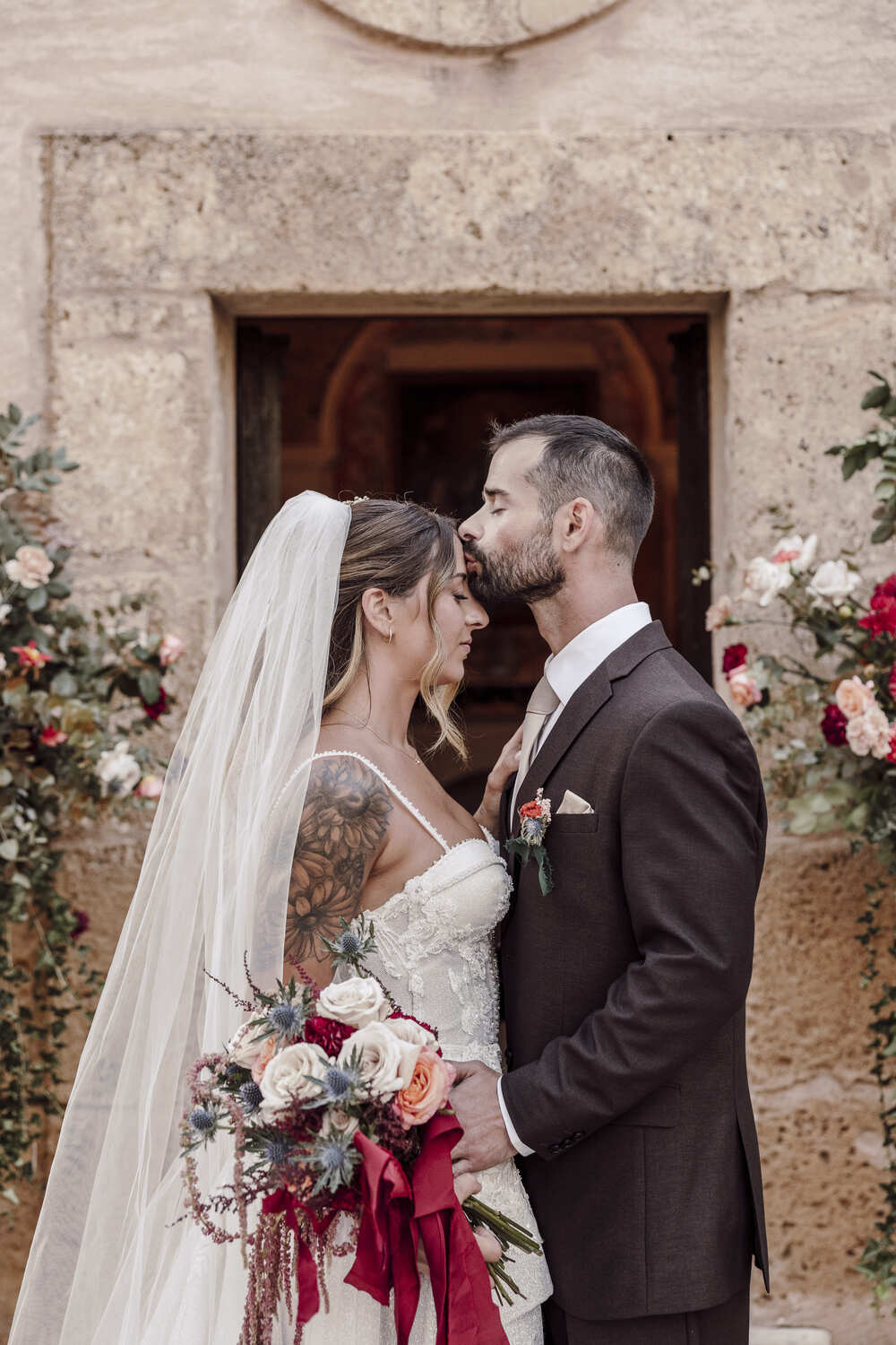 A bride in a lace wedding dress gently holds.