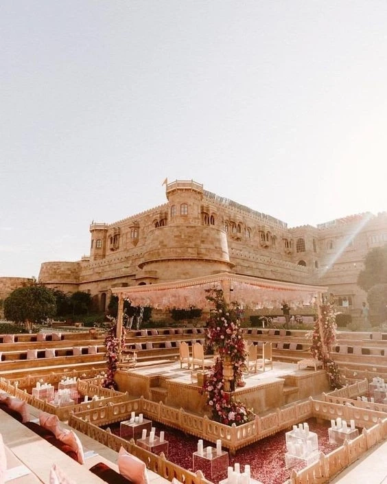 Architectural wedding venue surrounded by floral decor and natural sunlight, evoking elegance and timeless beauty, a breathtaking composition by Out of The Blues Fine Art Wedding Photography in Hyderabad.