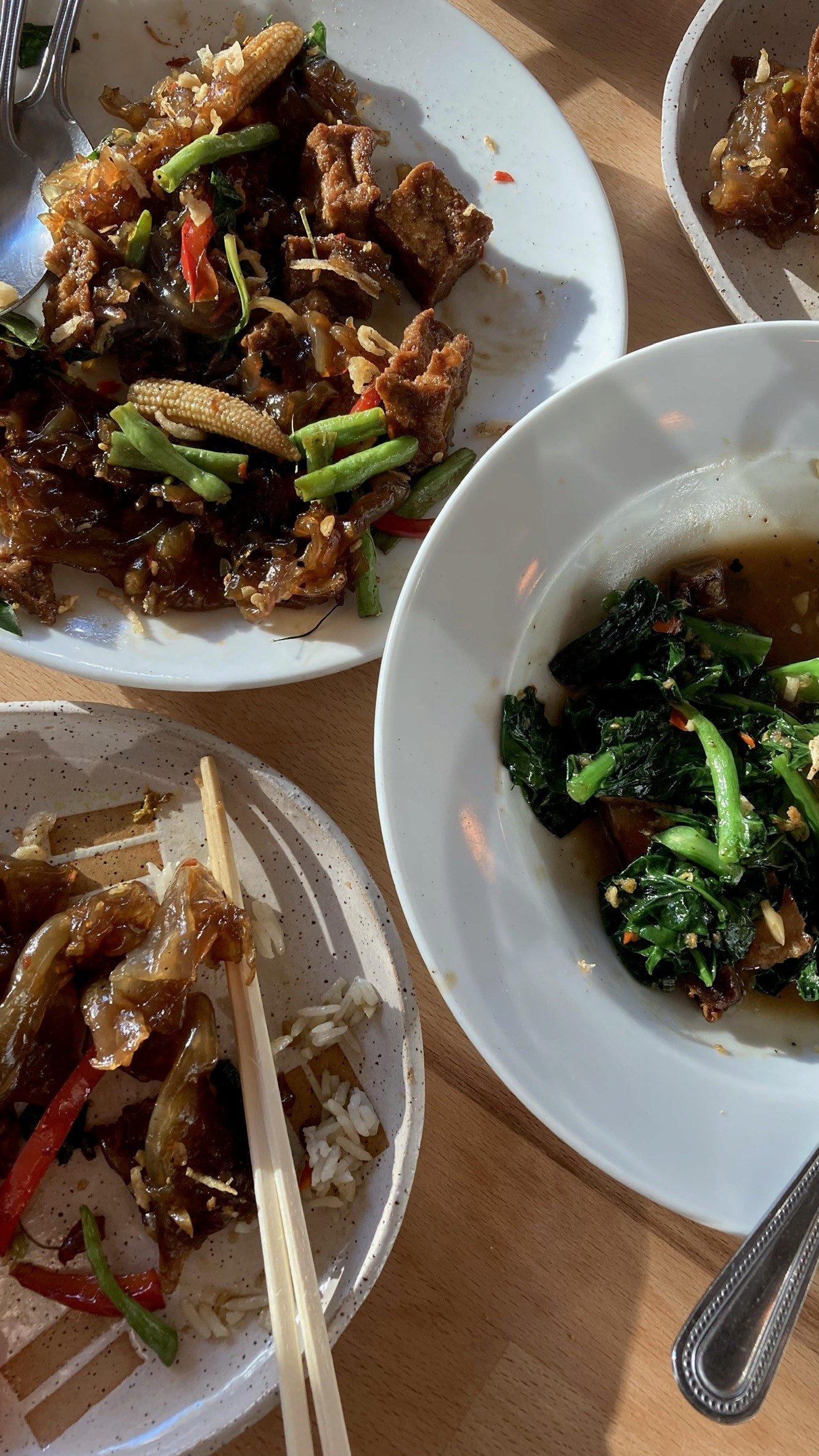 A green butterfly rests on a flower.