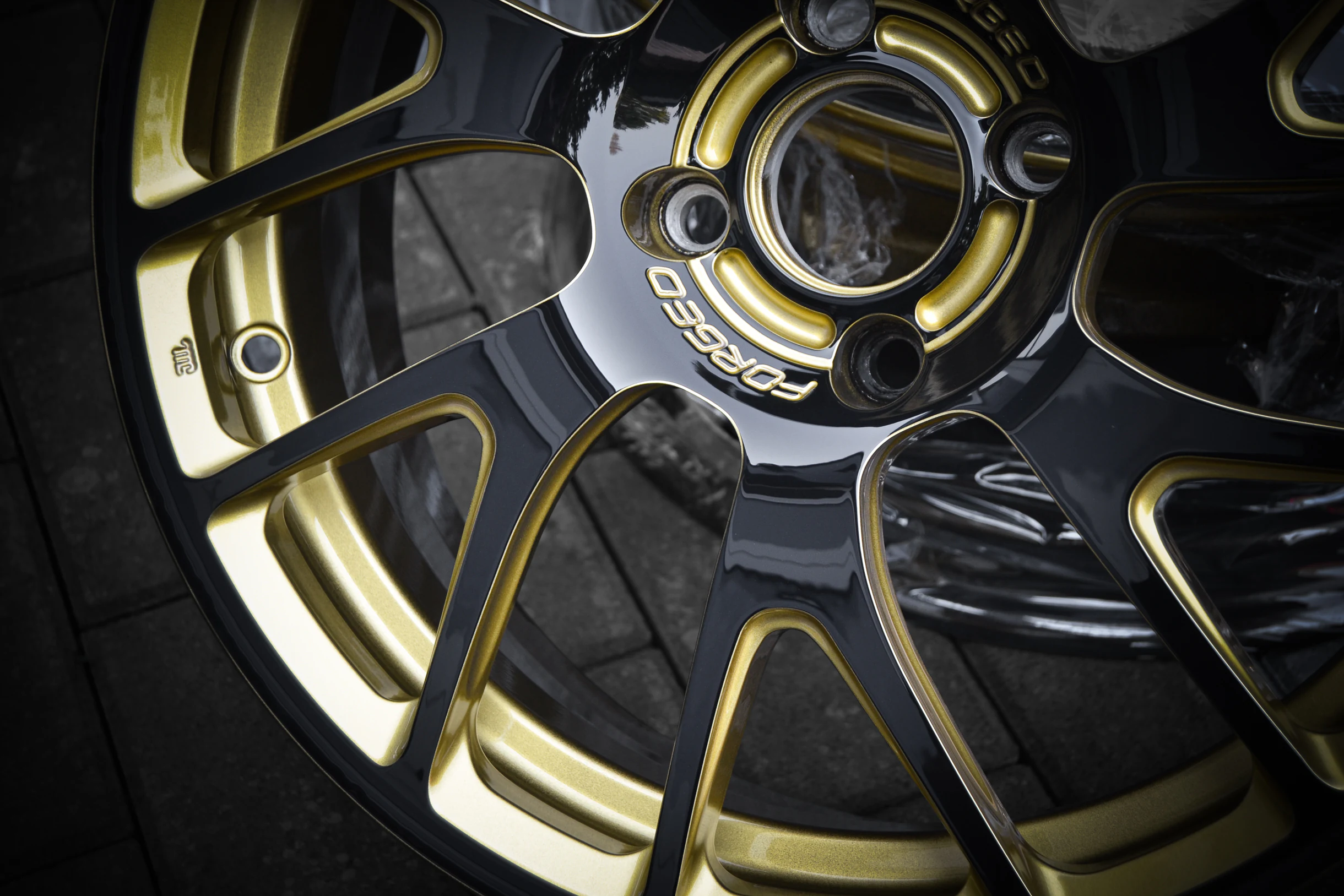 Detail der goldfarbenen Konturen und dunklen Speichenflächen bei AT Plus.
