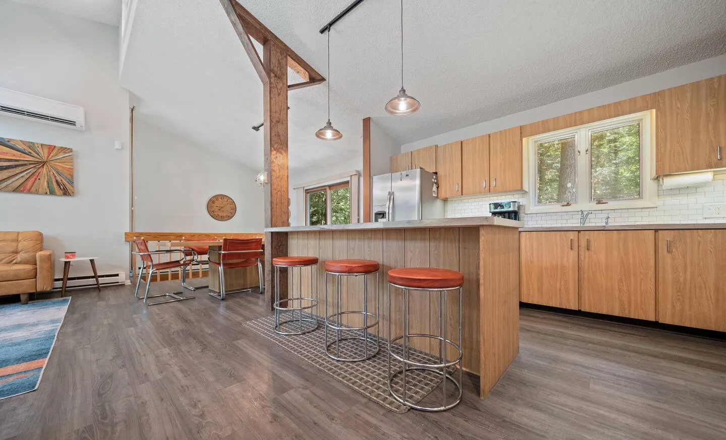 Open kitchen with island seating for three and red stools at Lake Front, Lake Naomi