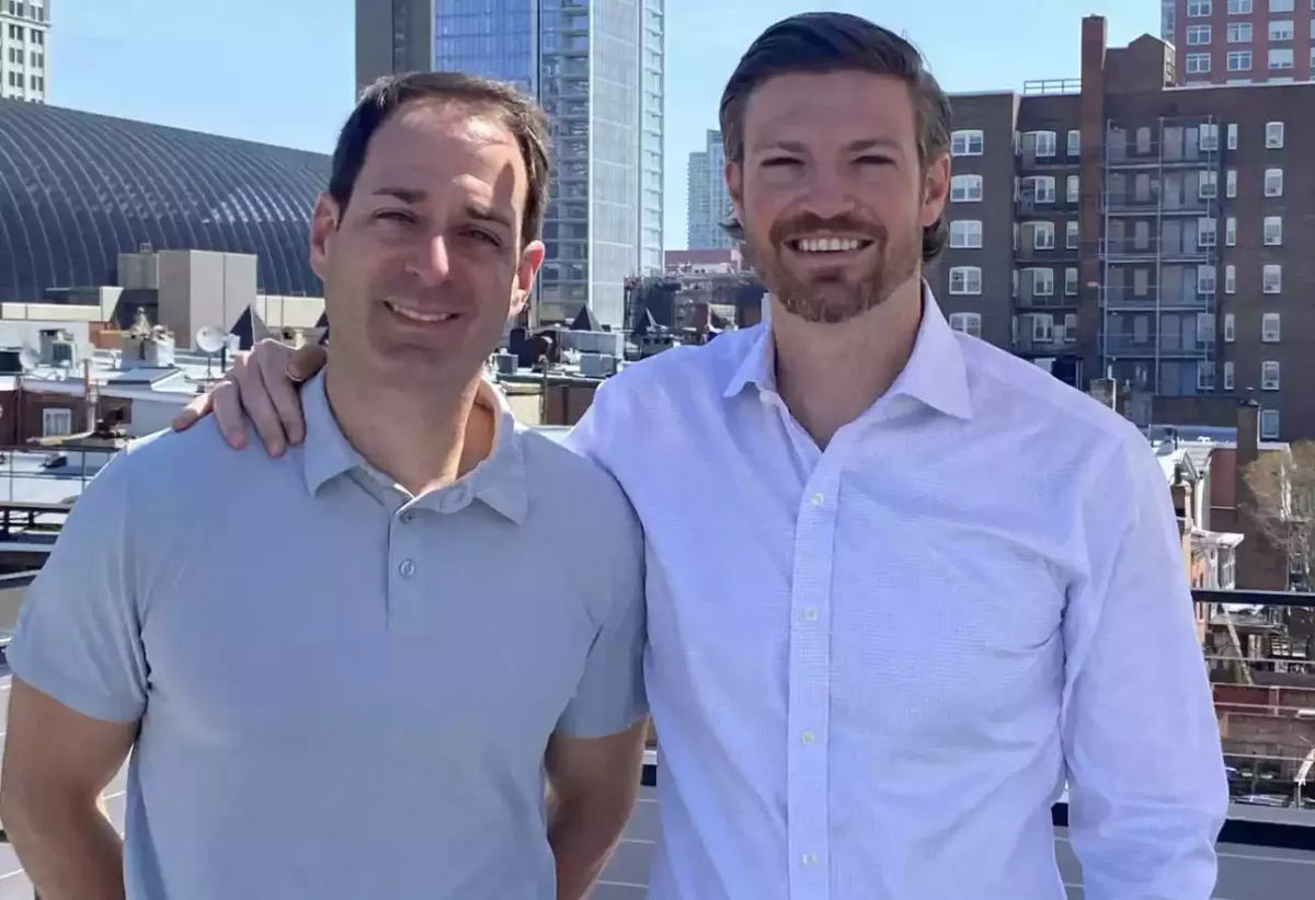 Alterra's two managing partners standing on a rooftop with the city behind them