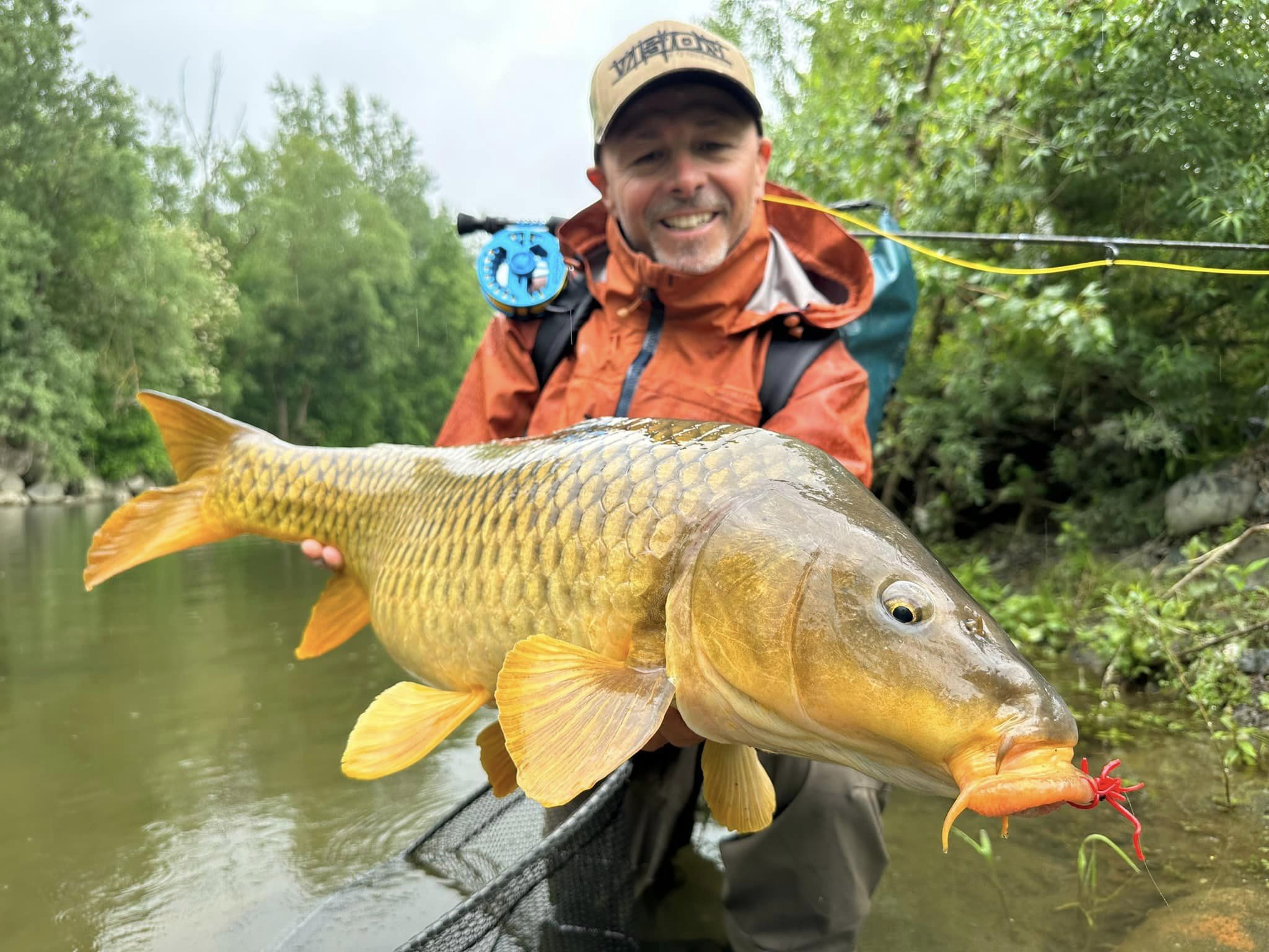 A guide demonstrating fly fishing techniques for barbel and carp in the scenic waters of the Po River.