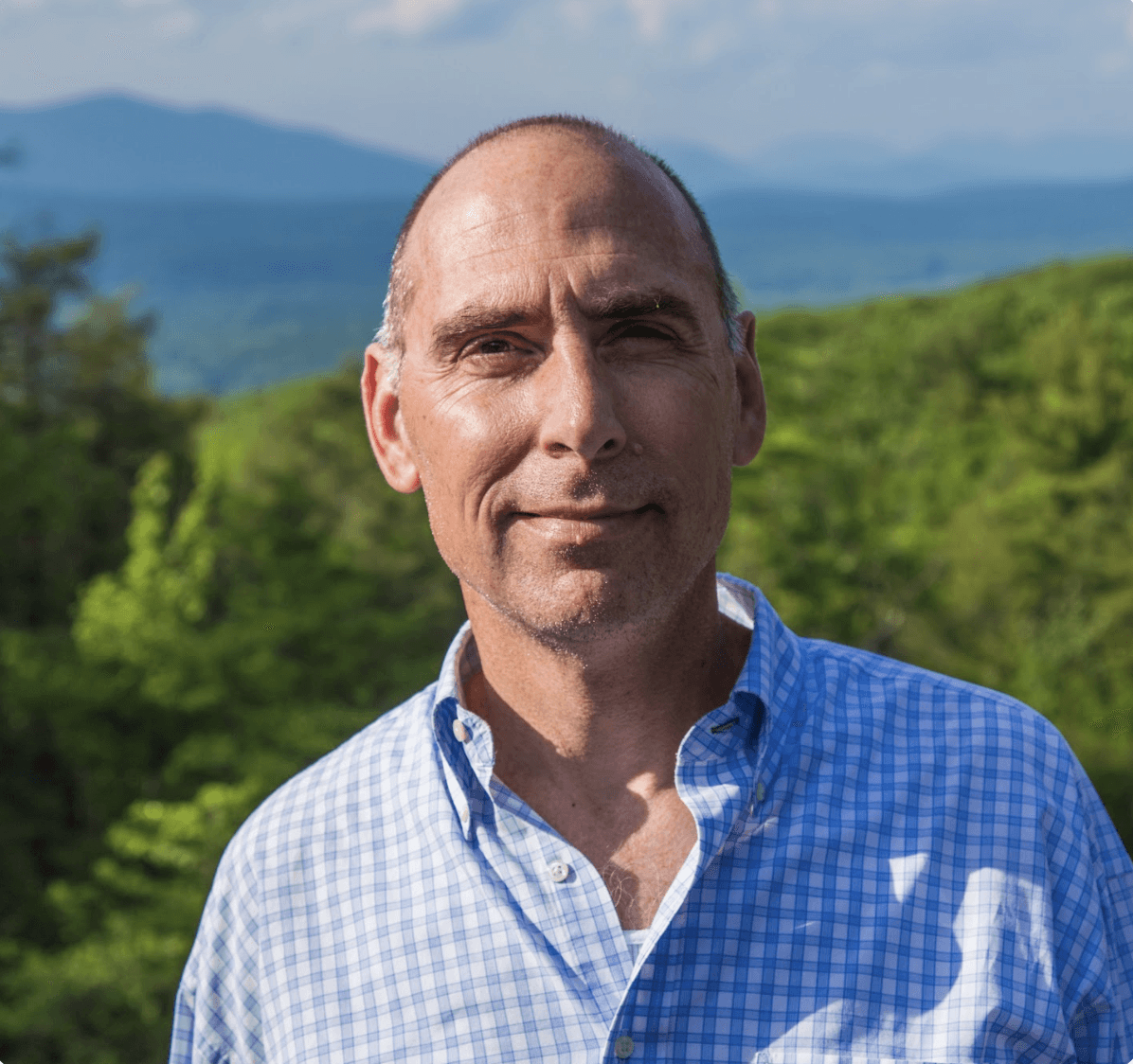 Cozy cafe corner with a round terrazzo table surrounded by wooden chairs, decorated with potted plants and a large mirror reflecting warm light.