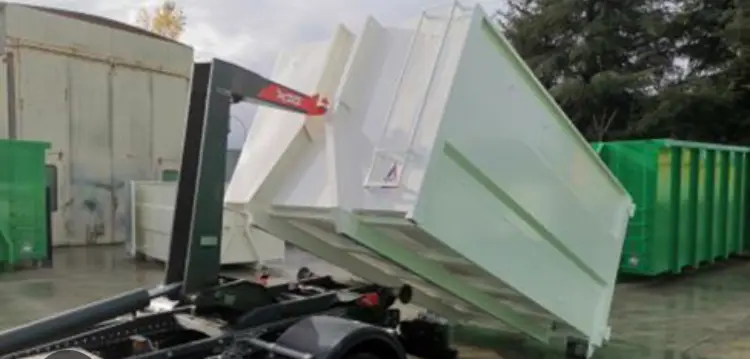 Benne blanche en train d'être descendue d'un camion