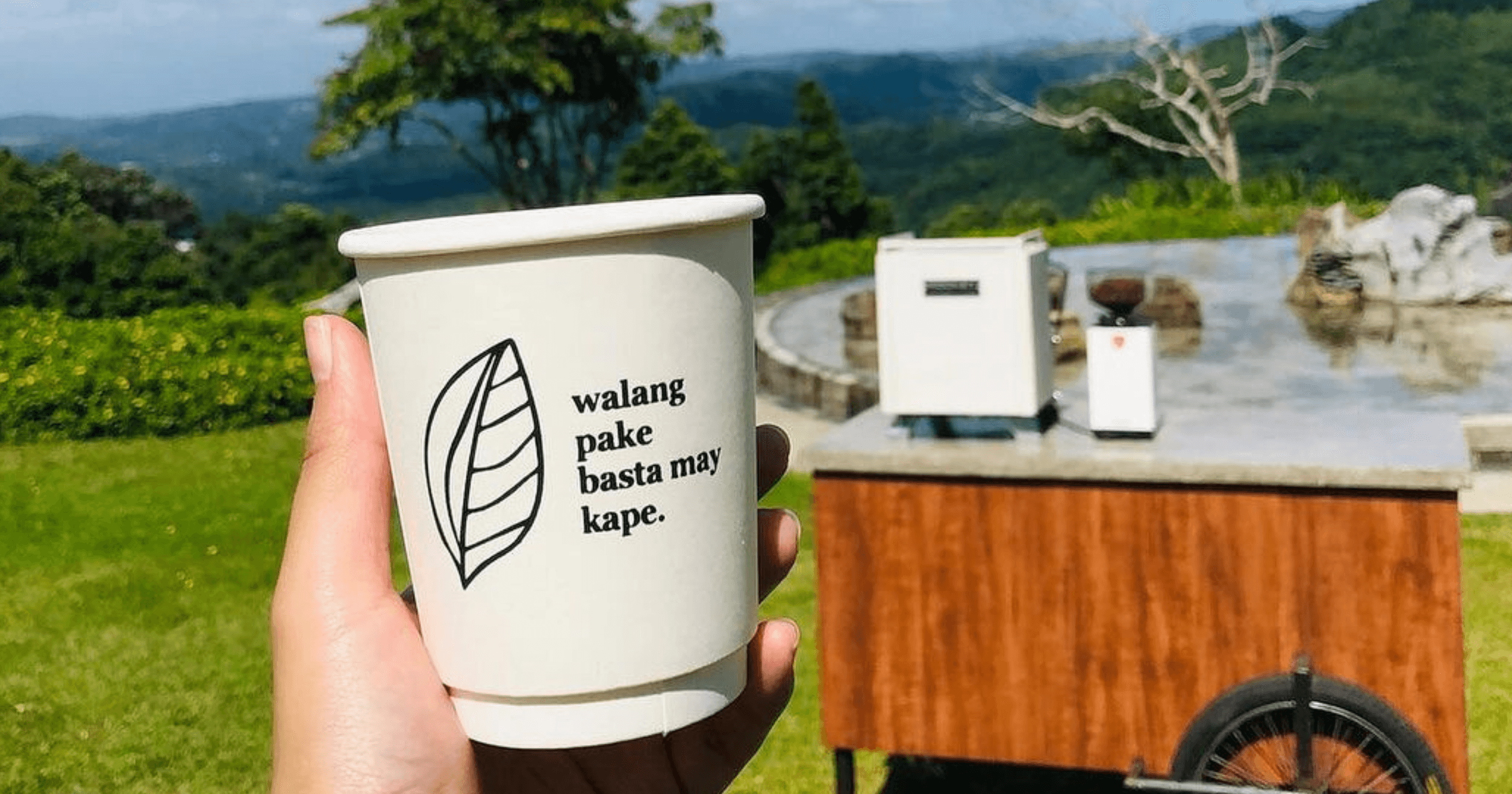 A person holding up a Candid Coffee cup