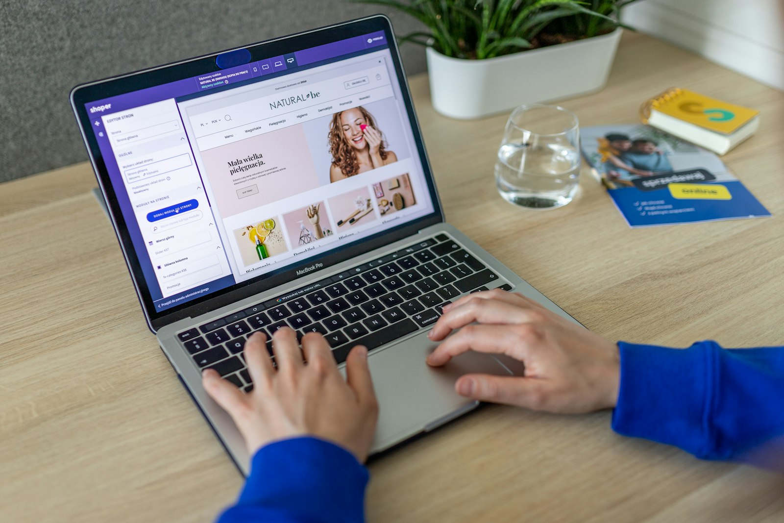 Webshopeigenaar werkt op een laptop aan de productpagina's van een online winkel