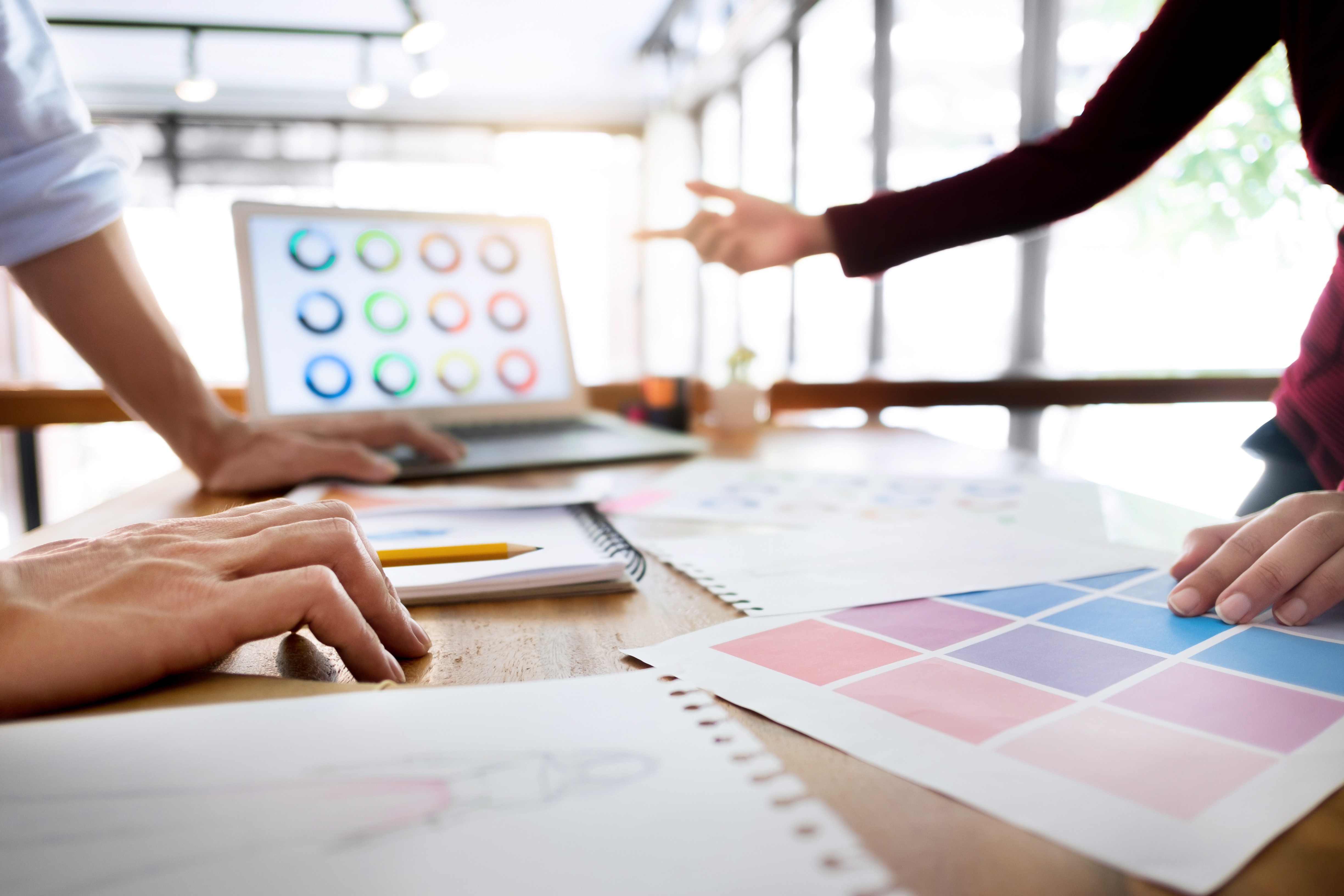 Creative team members collaborating on graphic design strategy in a modern workspace