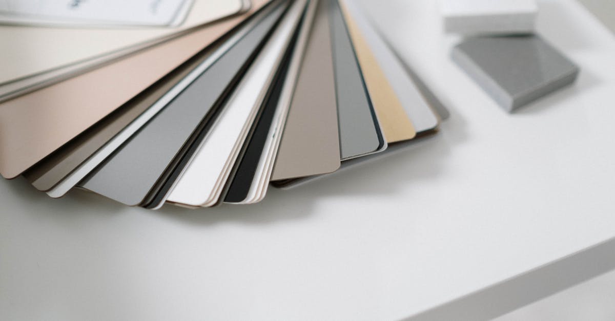 A variety of neutral color samples on a minimalist white desk for design purposes.