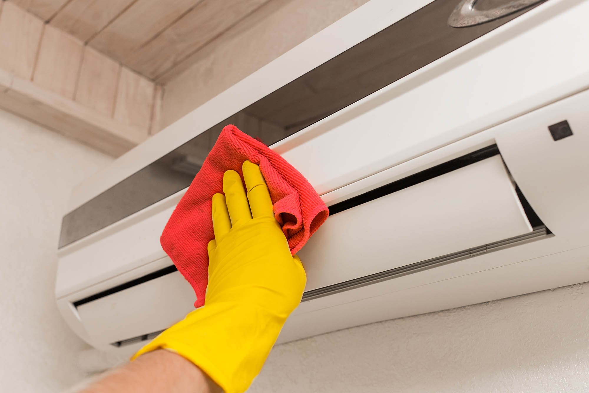A man cleaning an AC as part of a duct cleaning cost in Dubai service by Adams Care