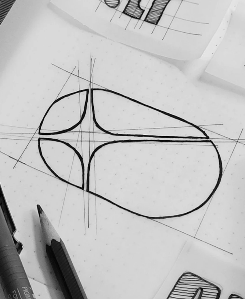 Close-up of a hand-drawn construction sketch of the Action Replay icon, the oval and four-point star traced over pencil guide lines.