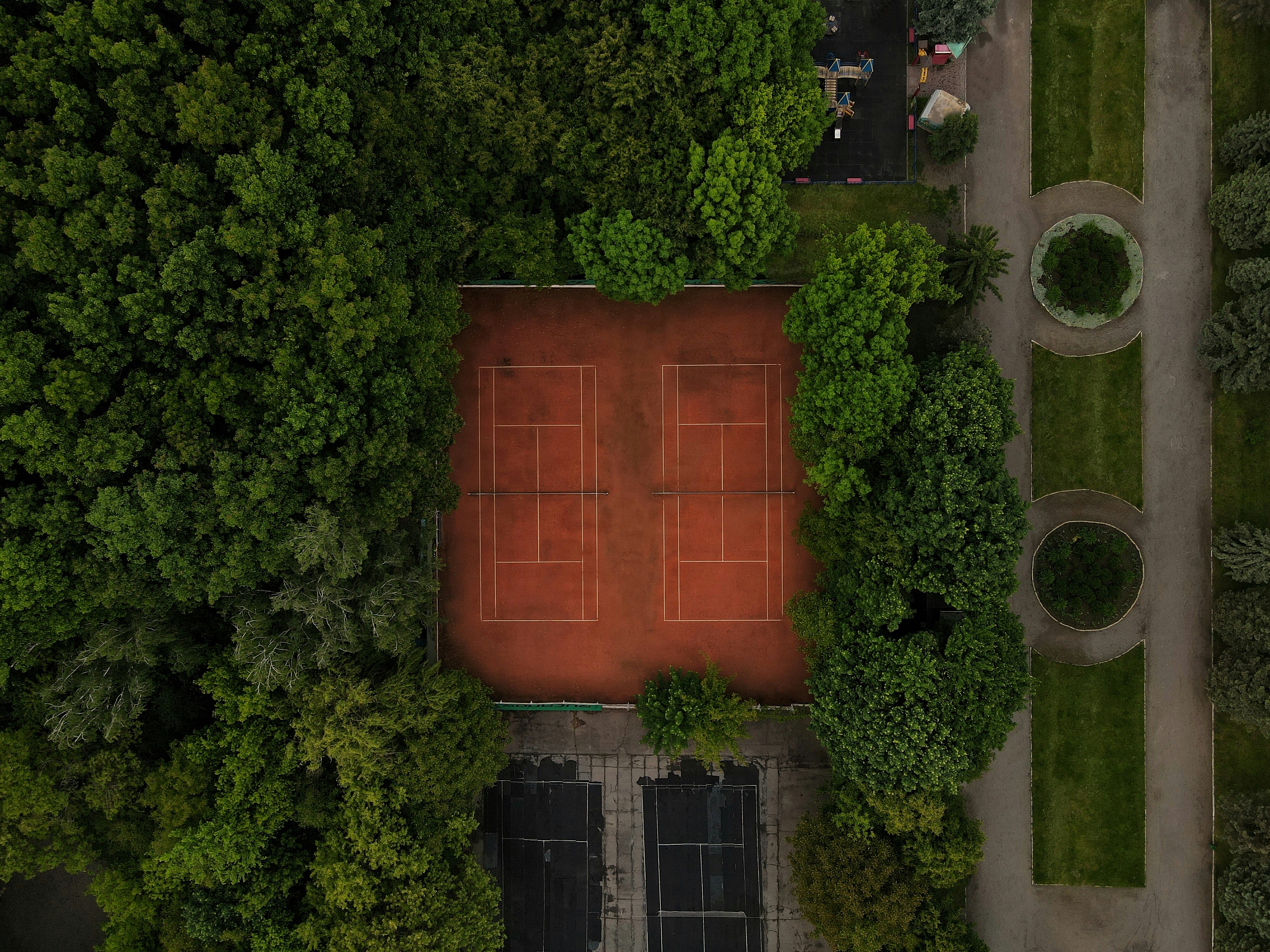 Two tennis clay courts on surounded by nature