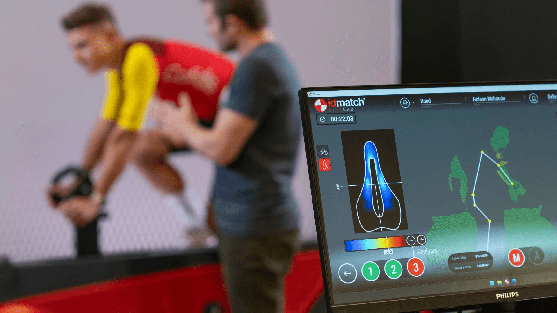 Interface du logiciel IDMatch Bikelab affichant l'analyse de pression de selle et la modélisation biomécanique du cycliste en temps réel.
