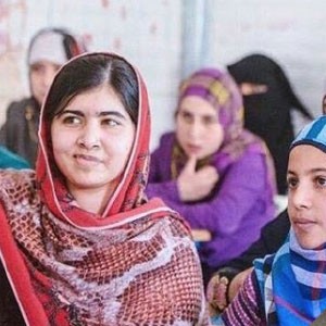 Young women in colorful hijabs attending a class, focused and attentive.