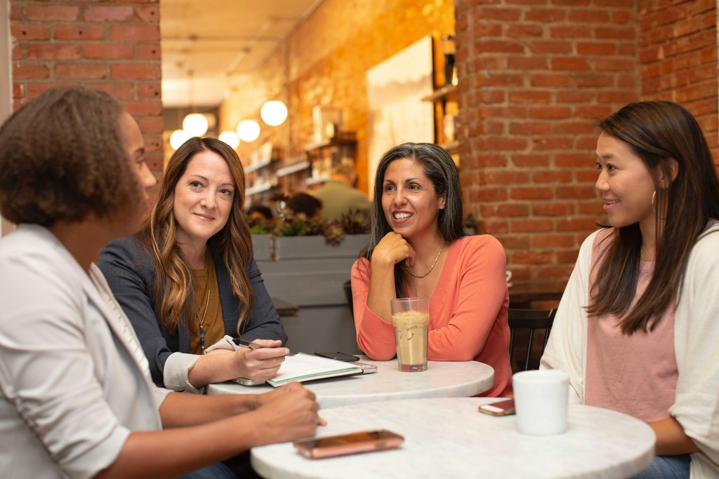 Four businesswomen having a conversation at a coffee shop