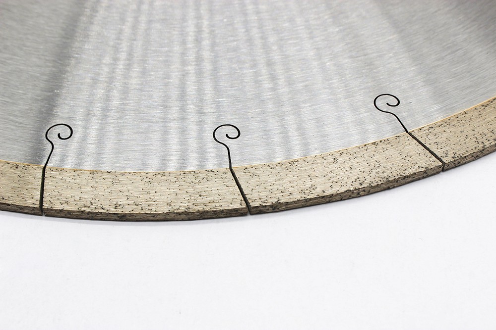 Close-up of the cutting edge on a sintered diamond saw blade for ceramic, showing detailed segments and narrow slots.