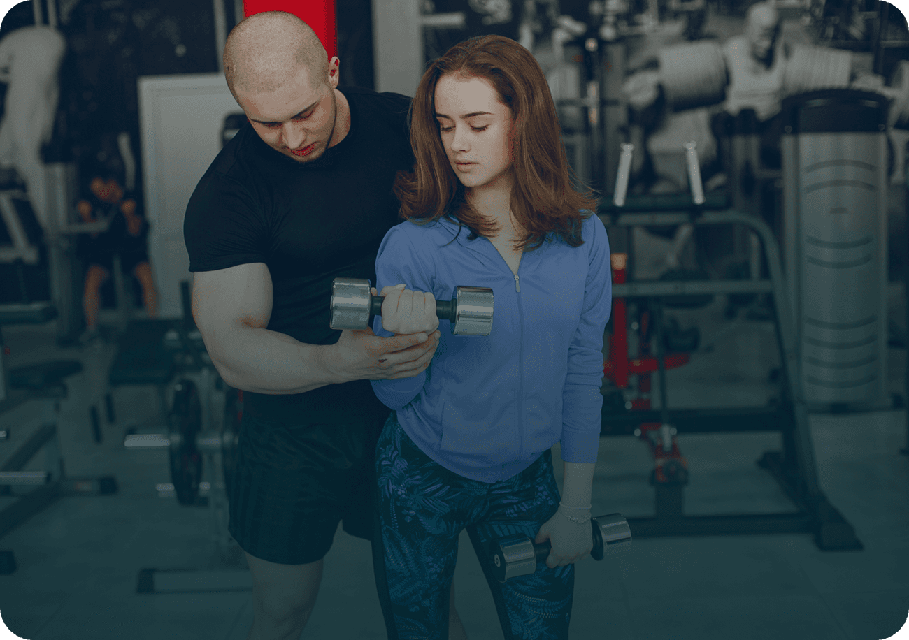 A young and beautiful girl with her boyfriend training in a gym