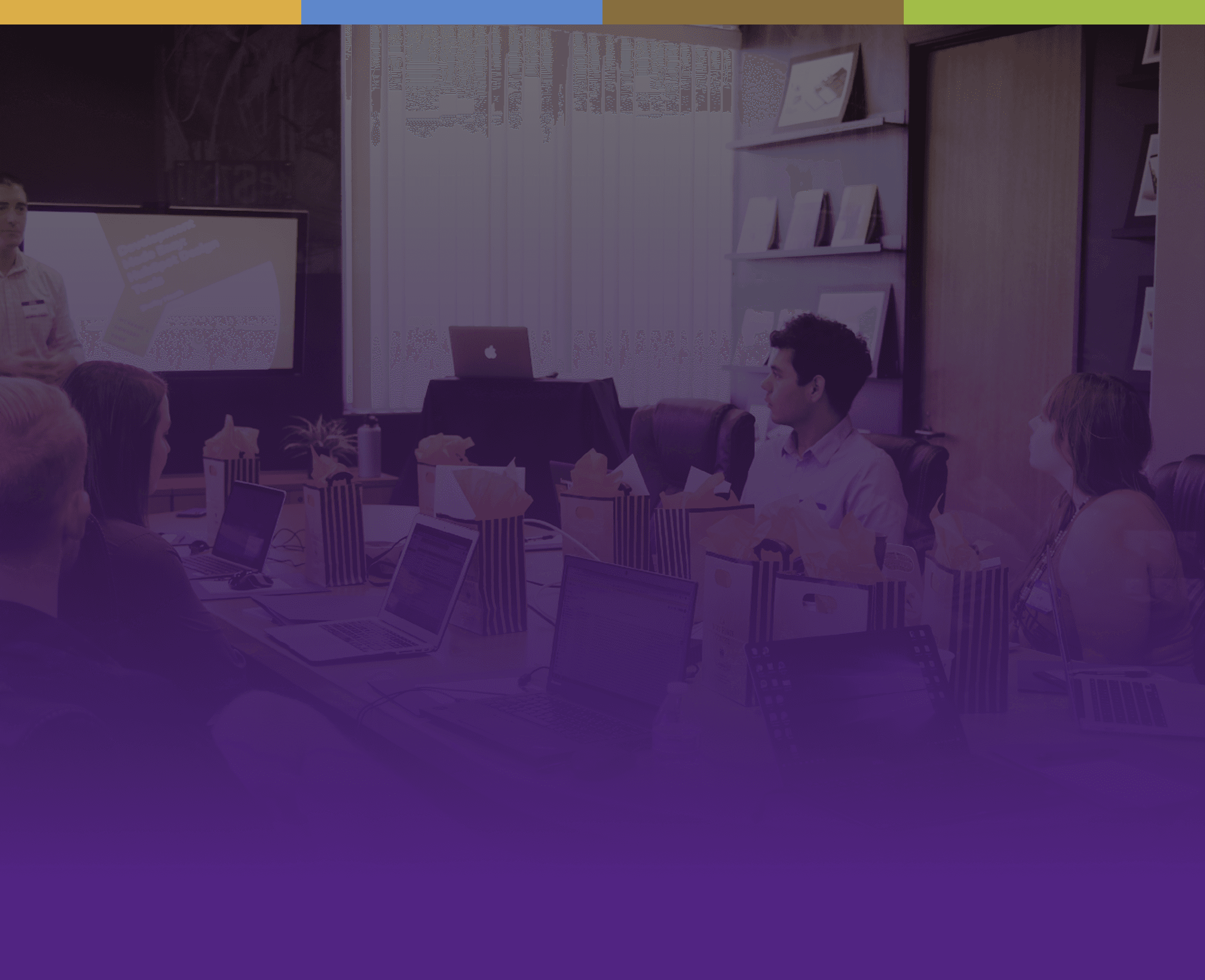 man standing in front of people sitting beside table with laptop computers